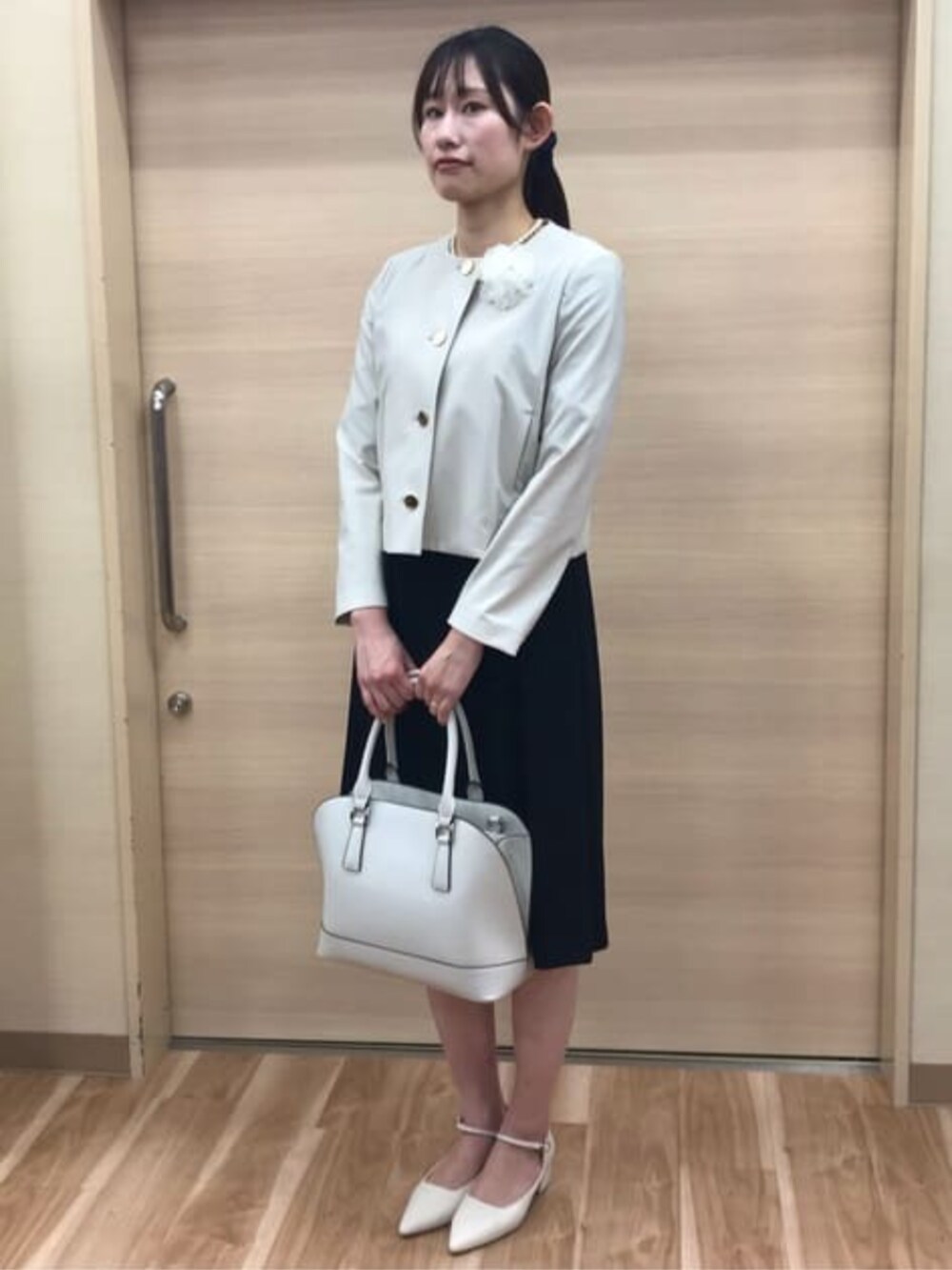 ベージュ系のスーツジャケット、ブラック系のスーツセットを着用したレディースの冬コーディネートの2枚目の写真