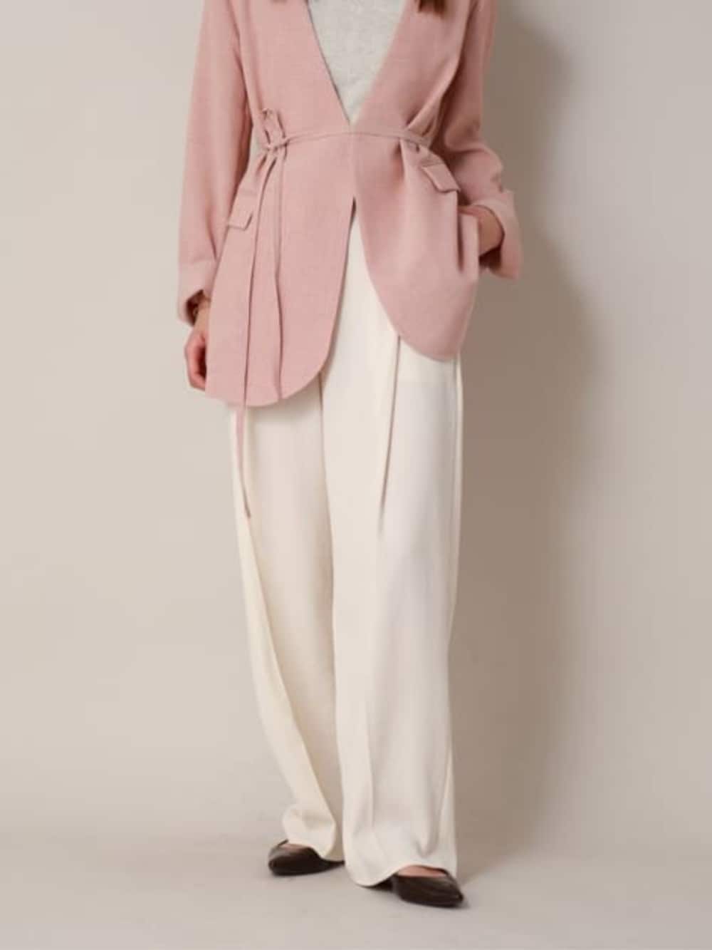 オレンジ系のテーラードジャケット、ホワイト系のスラックスを着用したレディースの冬コーディネートの5枚目の写真