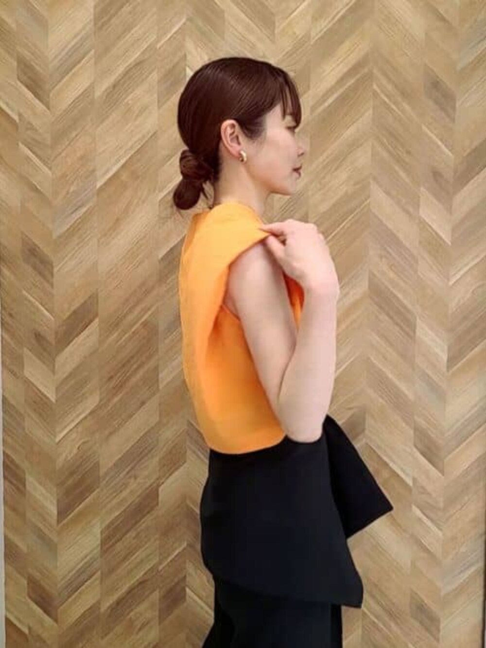 ブラック系のその他パンツ、オレンジ系のワンピースを着用したレディースの冬コーディネートの6枚目の写真