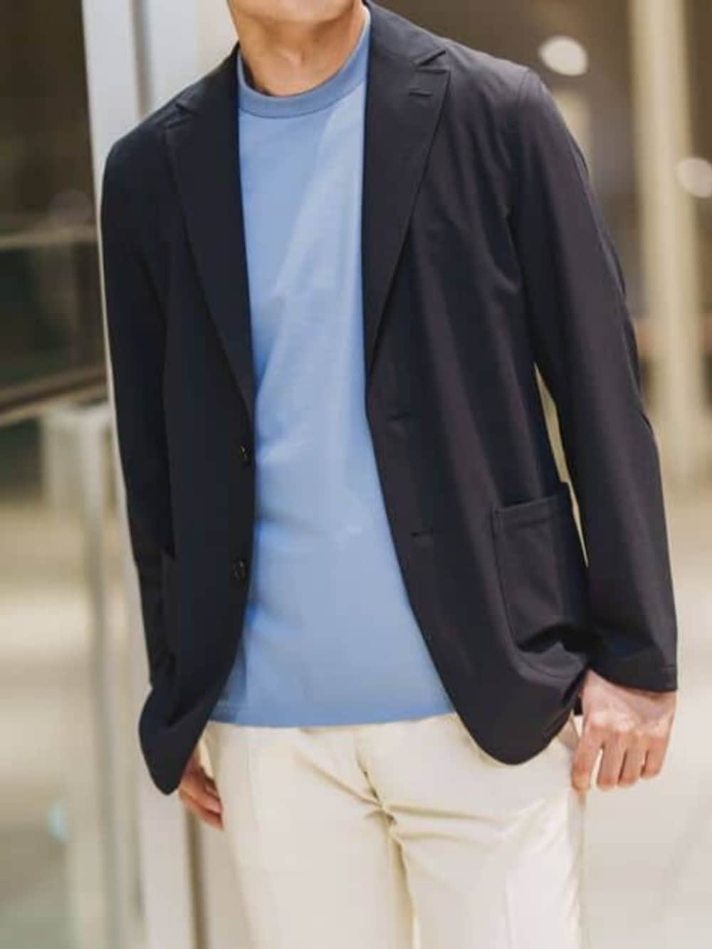 ブルー系のビジネスバッグ、ホワイト系のスラックスを着用したメンズの春コーディネートの4枚目の写真