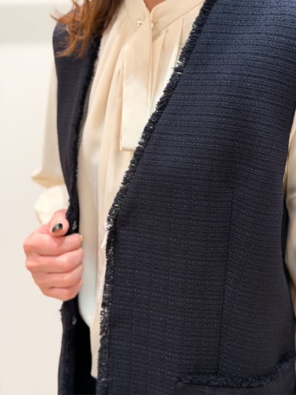 ベージュ系のシャツ/ブラウス、ブルー系のベスト、ブルー系のスラックスを着用したレディースの冬コーディネートの2枚目の写真