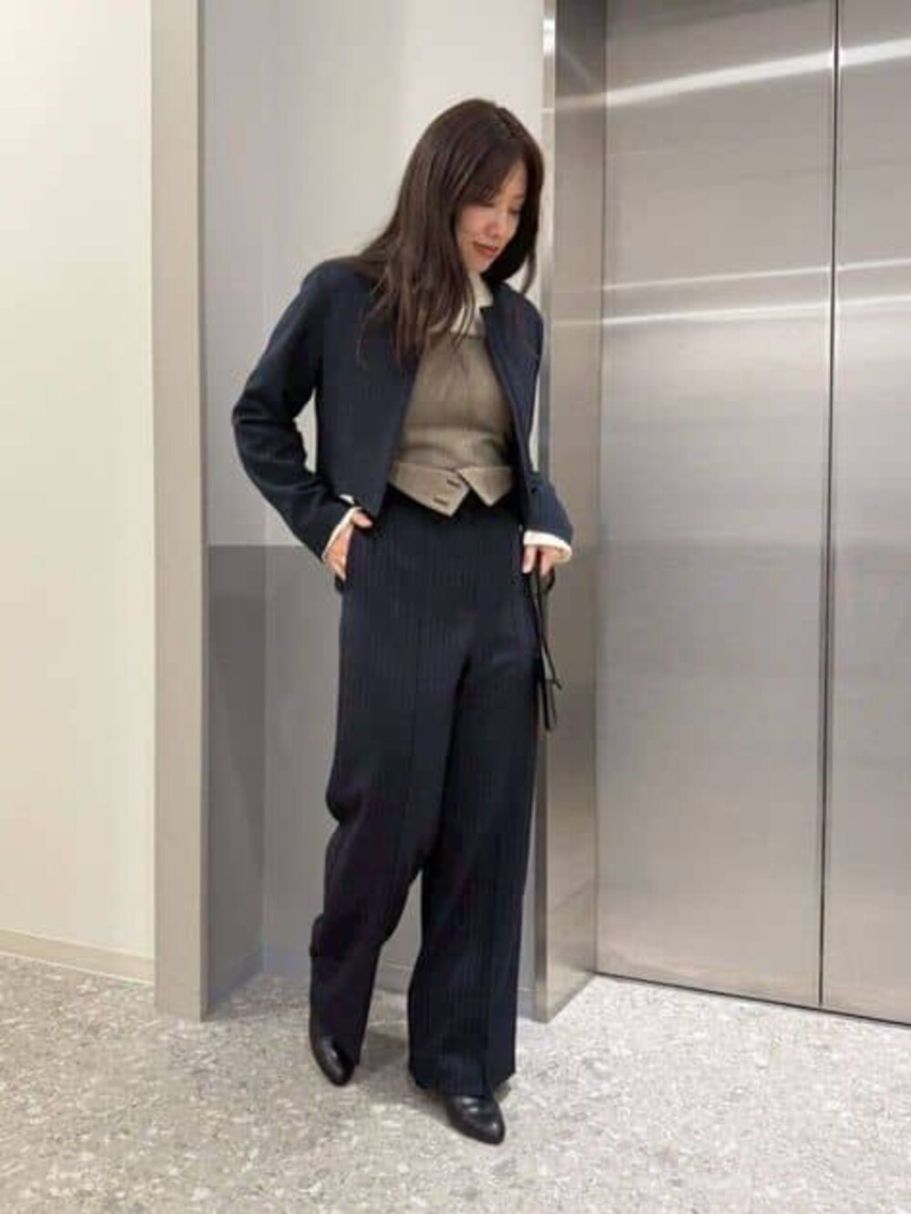 ベージュ系のその他パンツ、ホワイト系のニット/セーター、ブルー系のブルゾンを着用したレディースの冬コーディネートの2枚目の写真