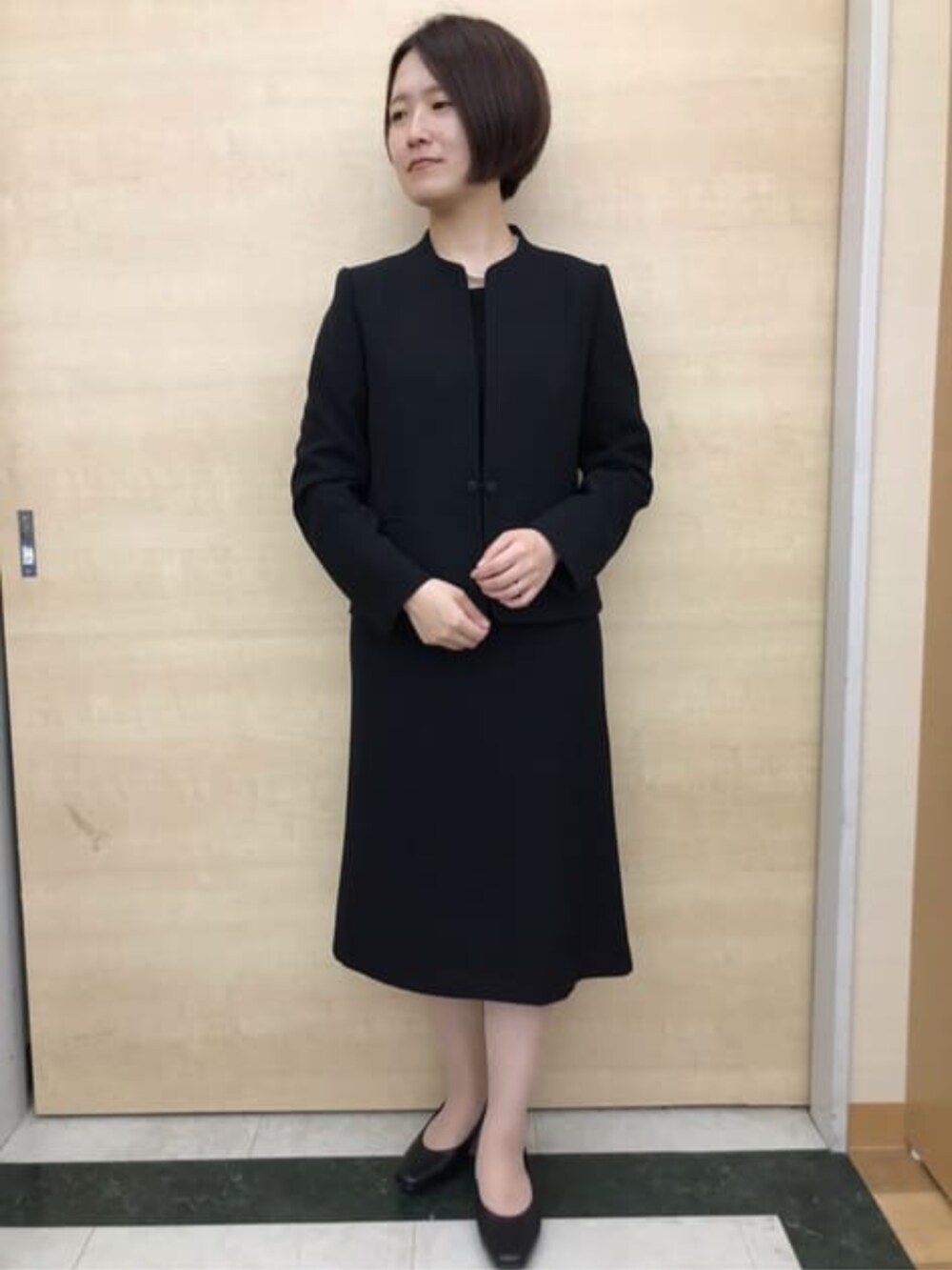 ブラック系のスーツセットを着用したレディースの冬コーディネートの2枚目の写真