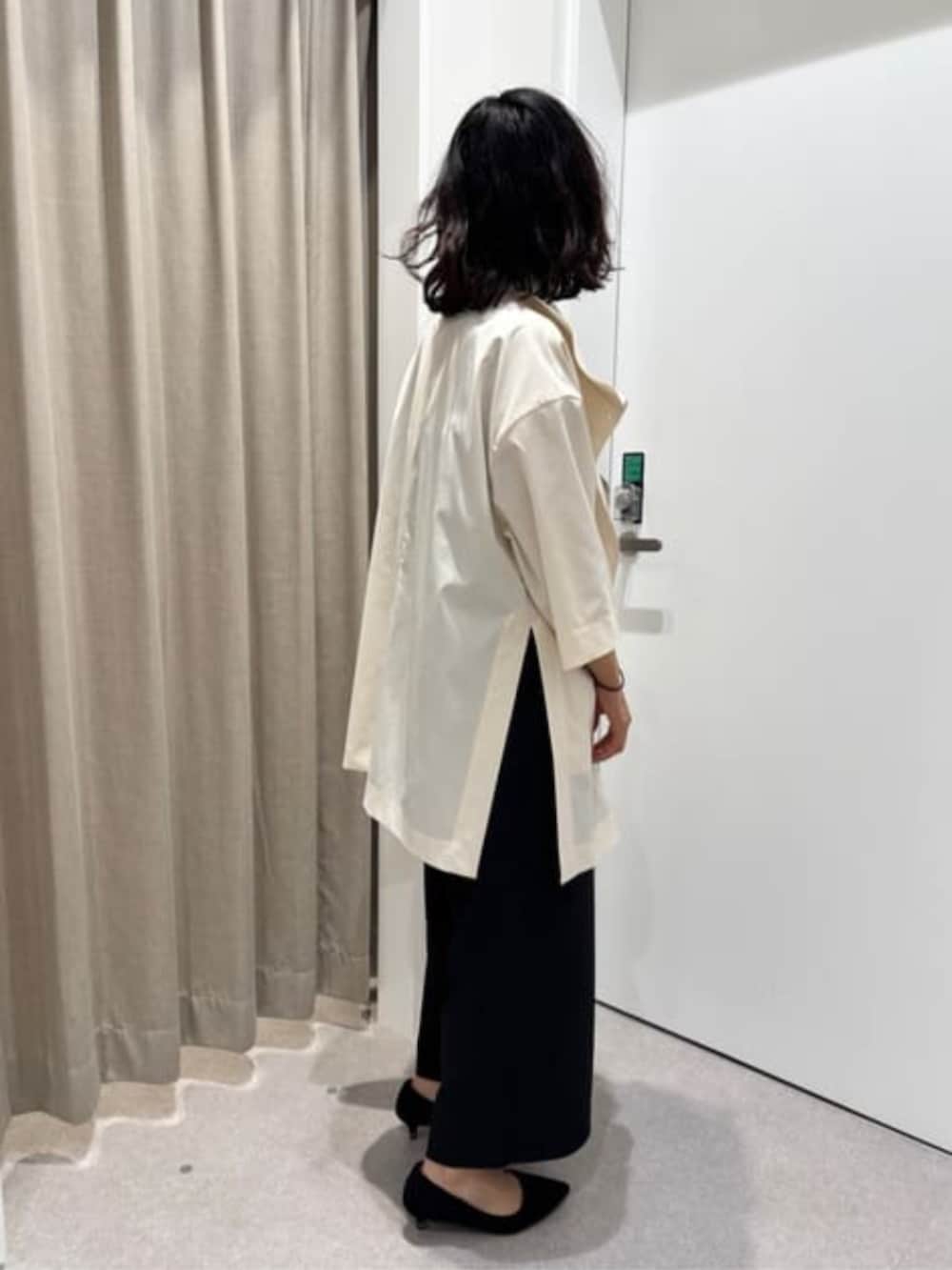 ブラック系のワンピース、ホワイト系のその他アウターを着用したレディースの冬コーディネートの7枚目の写真