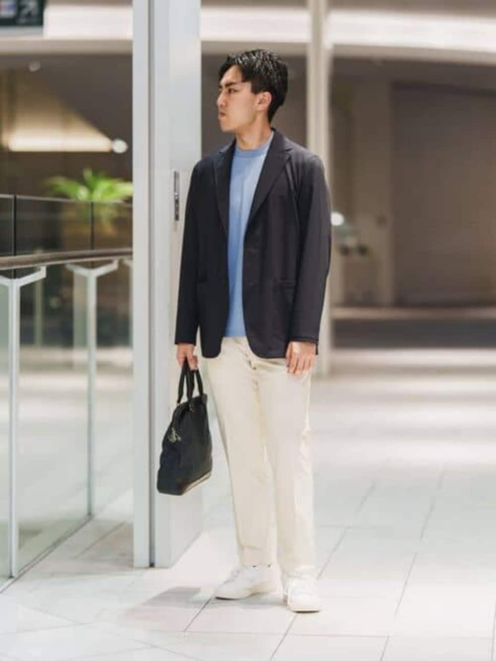 ブルー系のビジネスバッグ、ホワイト系のスラックスを着用したメンズの春コーディネートの2枚目の写真