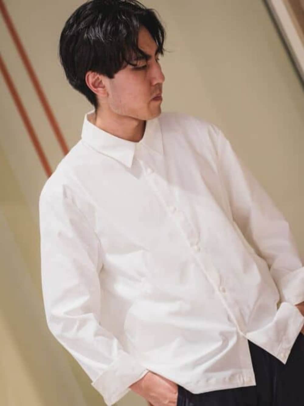 ホワイト系のテーラードジャケット、ブルー系のスラックスを着用したメンズの春コーディネートの2枚目の写真