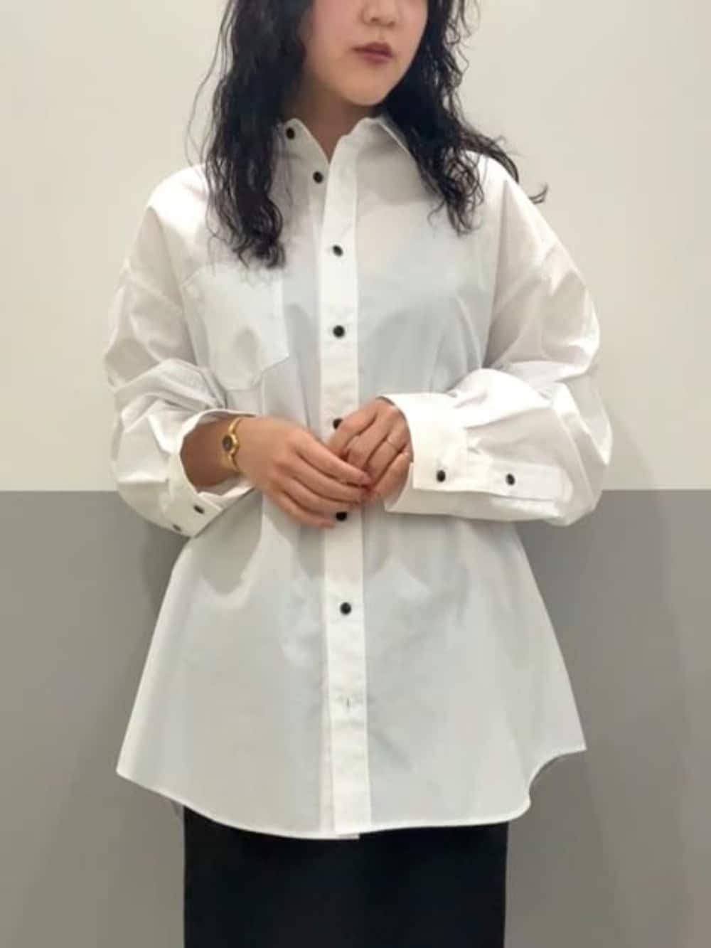 ホワイト系のシャツ/ブラウス、ブラック系のスカート、ブラック系のベストを着用したレディースの冬コーディネートの8枚目の写真