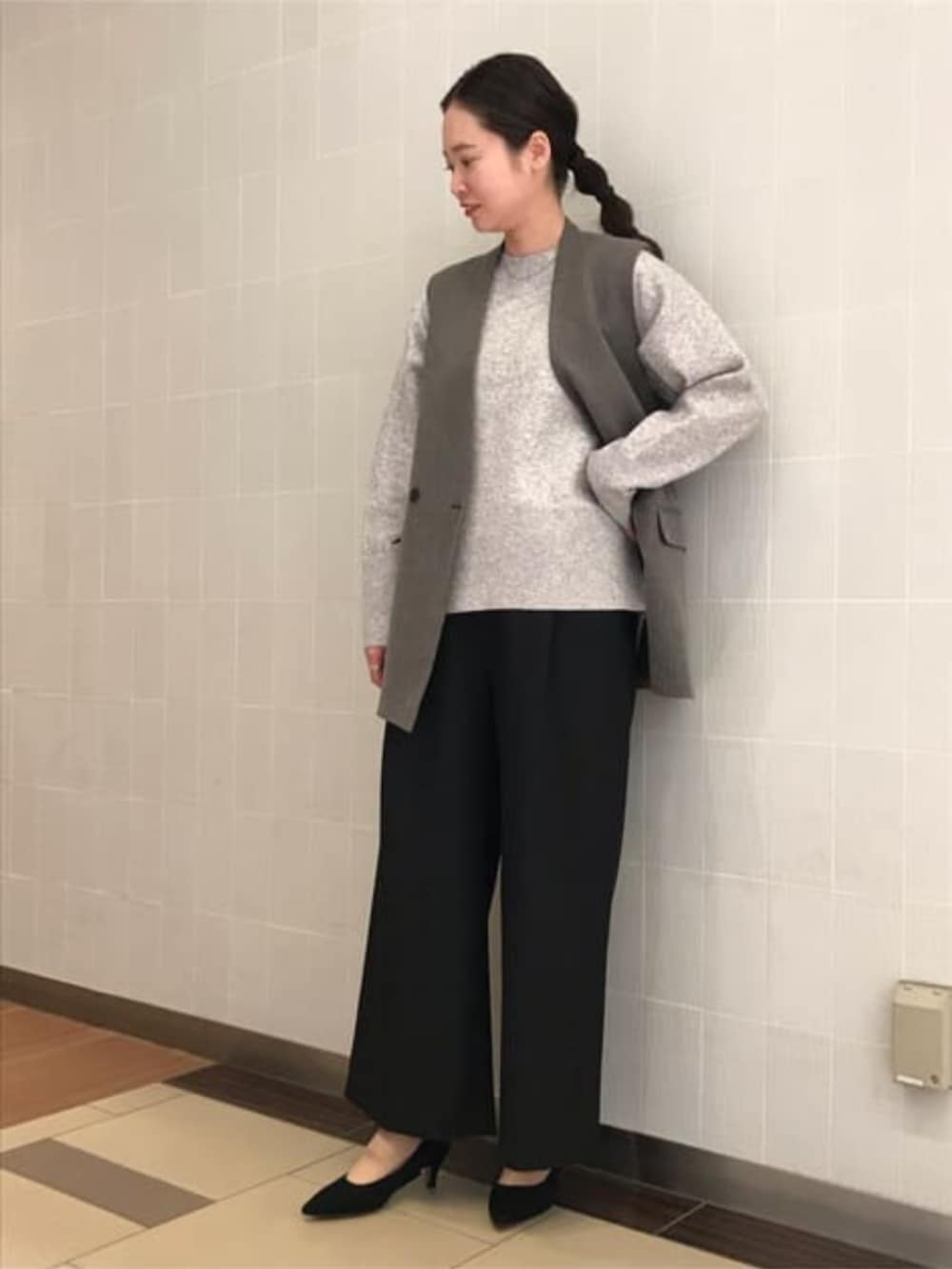 グレー系のニット/セーター、グレー系のベスト、ブラック系のスラックスを着用したレディースの冬コーディネートの3枚目の写真