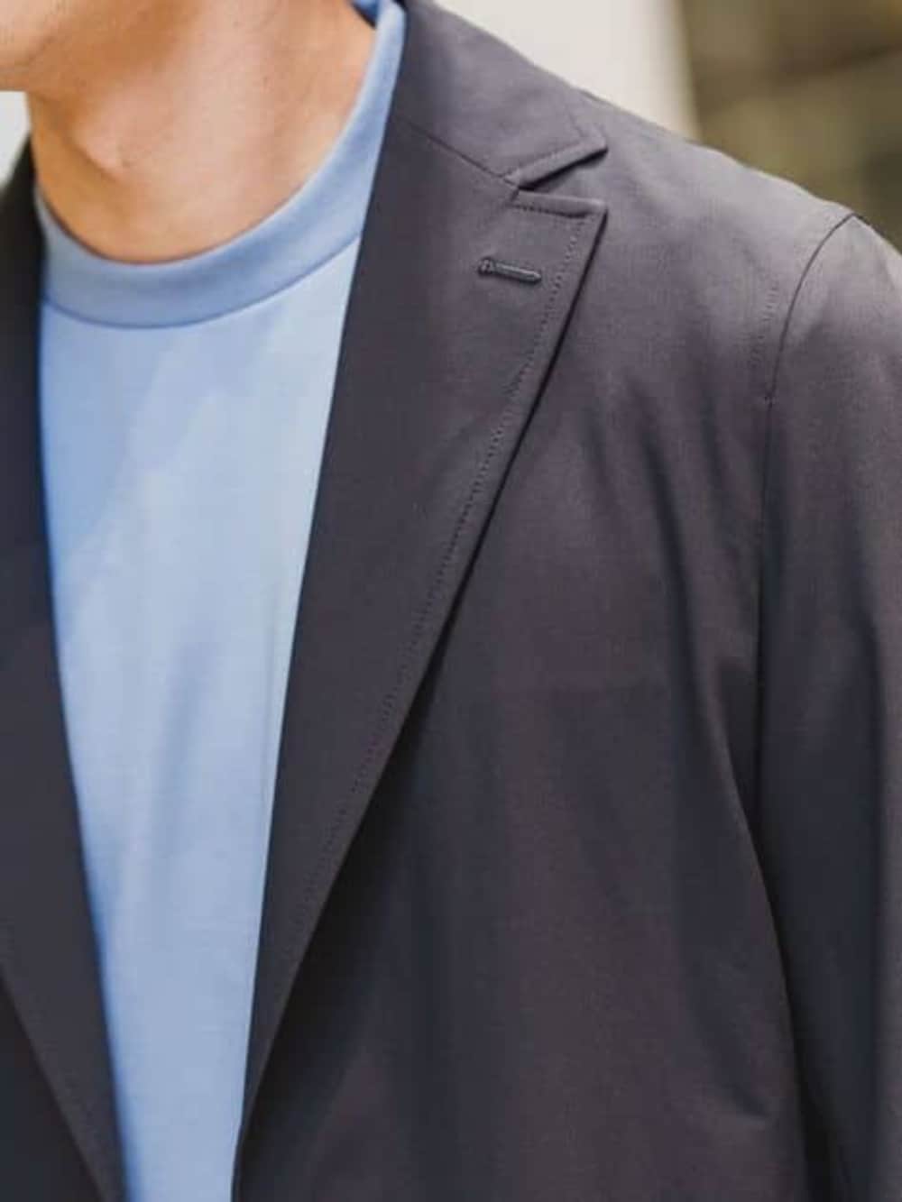 ブルー系のビジネスバッグ、ホワイト系のスラックスを着用したメンズの春コーディネートの5枚目の写真