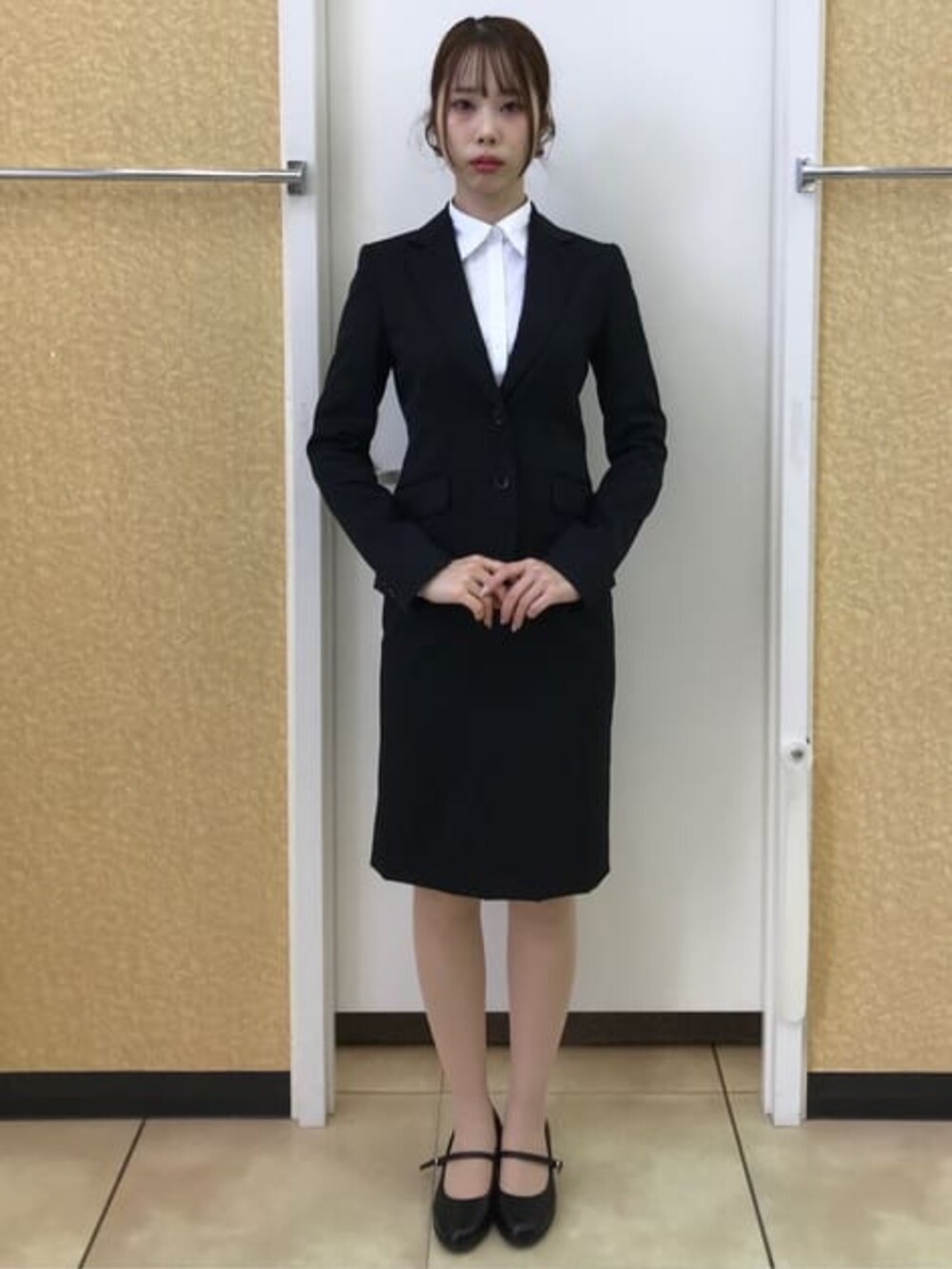 ブラック系のスーツジャケット、ブラック系のスーツスカートを着用したレディースの冬コーディネートの2枚目の写真