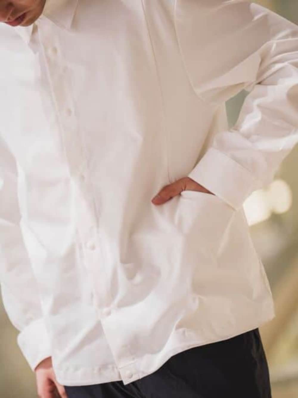 ホワイト系のテーラードジャケット、ブルー系のスラックスを着用したメンズの春コーディネートの5枚目の写真