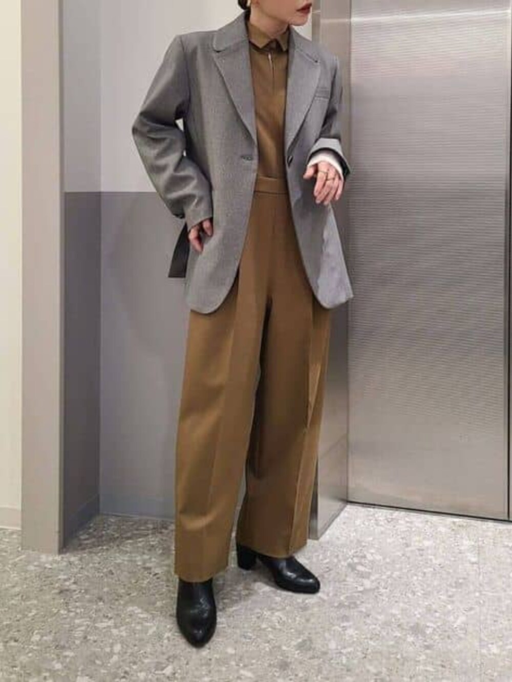 グレー系のテーラードジャケット、ベージュ系のつなぎ/オールインワンを着用したレディースの冬コーディネートの2枚目の写真