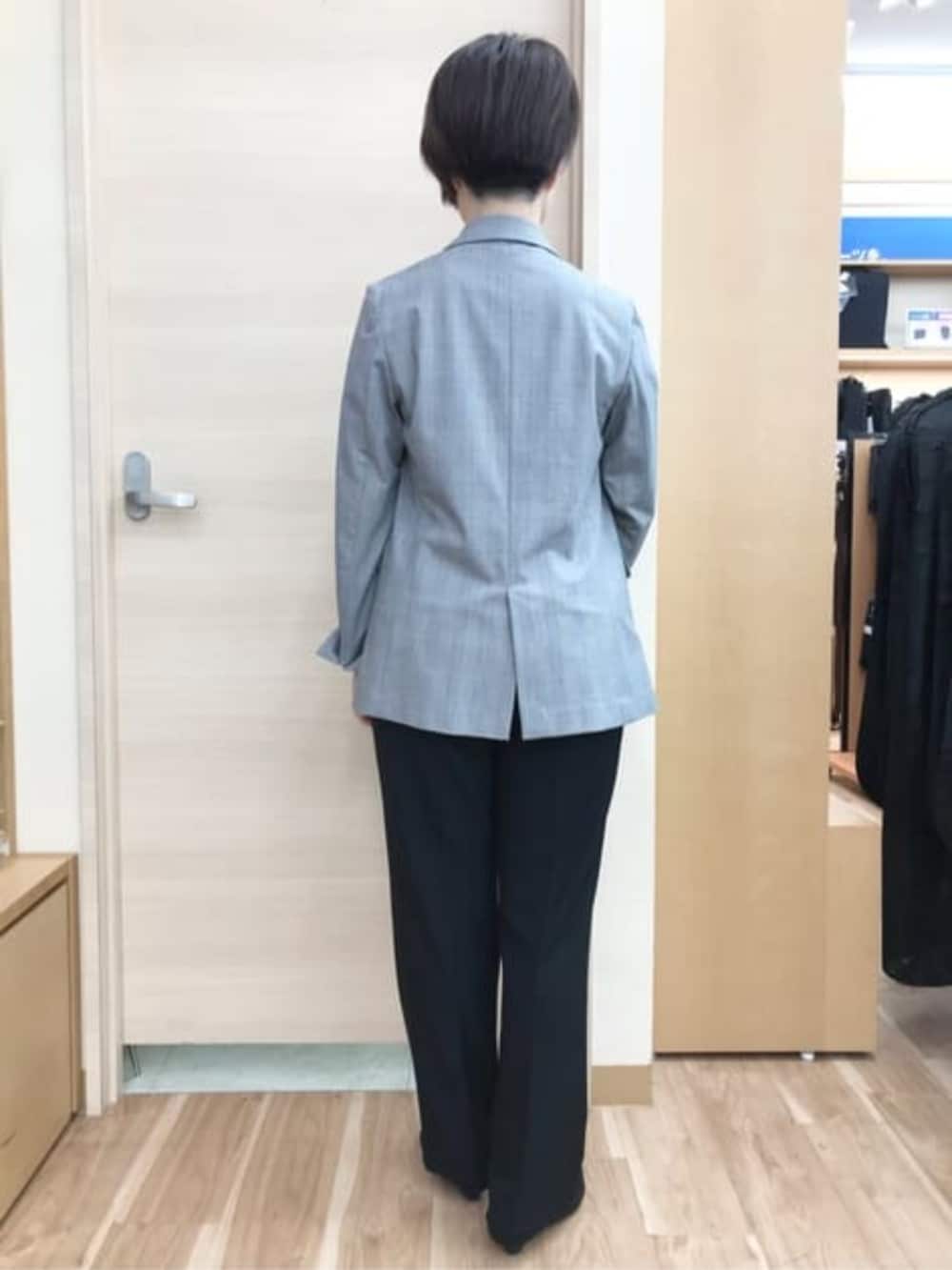 ブラック系のスーツパンツ、グレー系のスーツジャケット、ベージュ系のシャツ/ブラウスを着用したレディースの春コーディネートの2枚目の写真