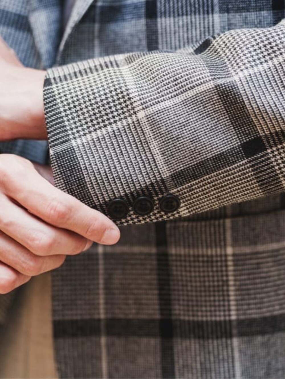 グレー系のテーラードジャケット、グレー系のスラックス、ブラウン系のニット/セーターを着用したメンズの冬コーディネートの5枚目の写真