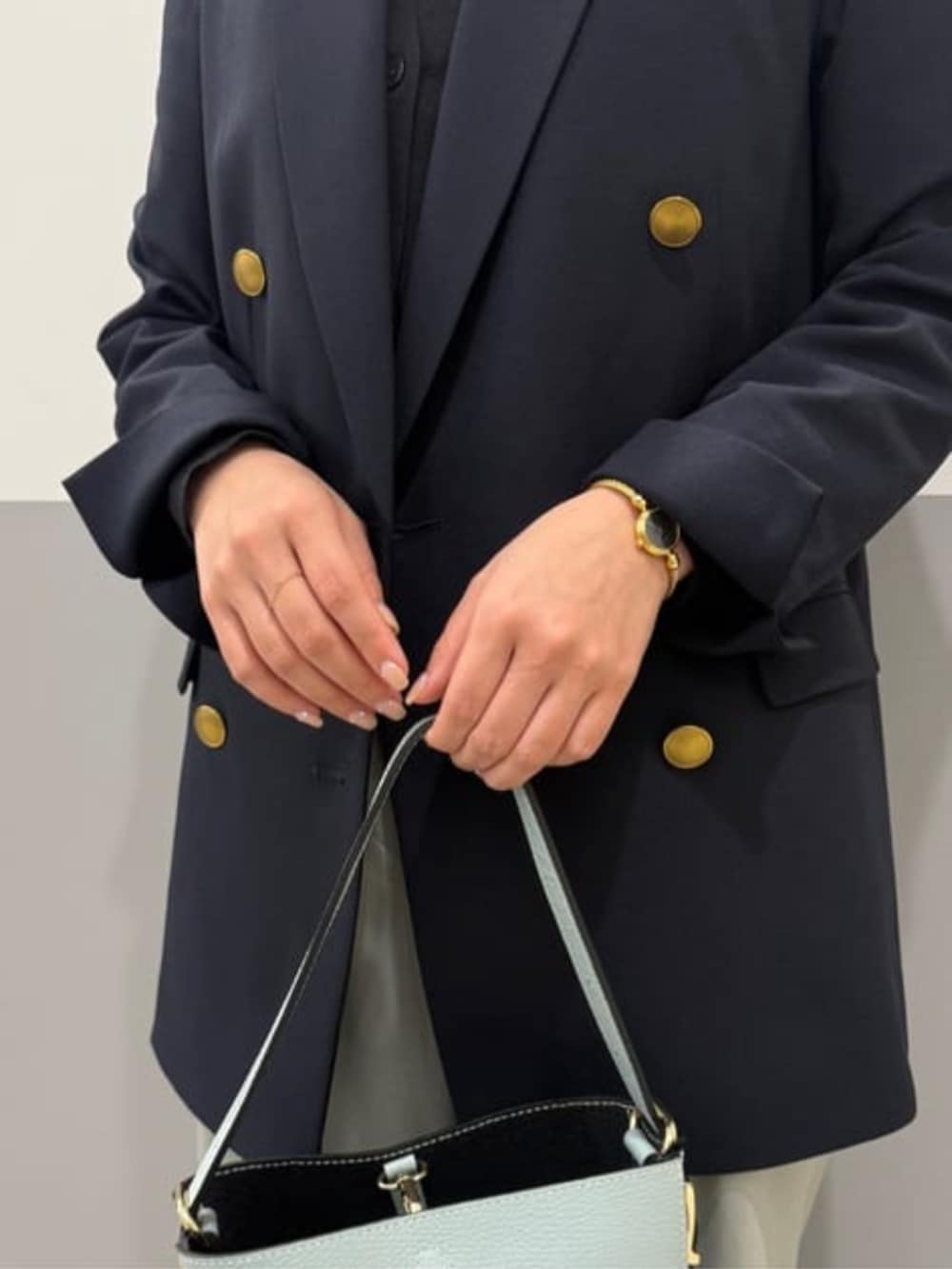 ブルー系のテーラードジャケット、グリーン系のその他パンツ、グリーン系のハンドバッグを着用したレディースの春コーディネートの4枚目の写真