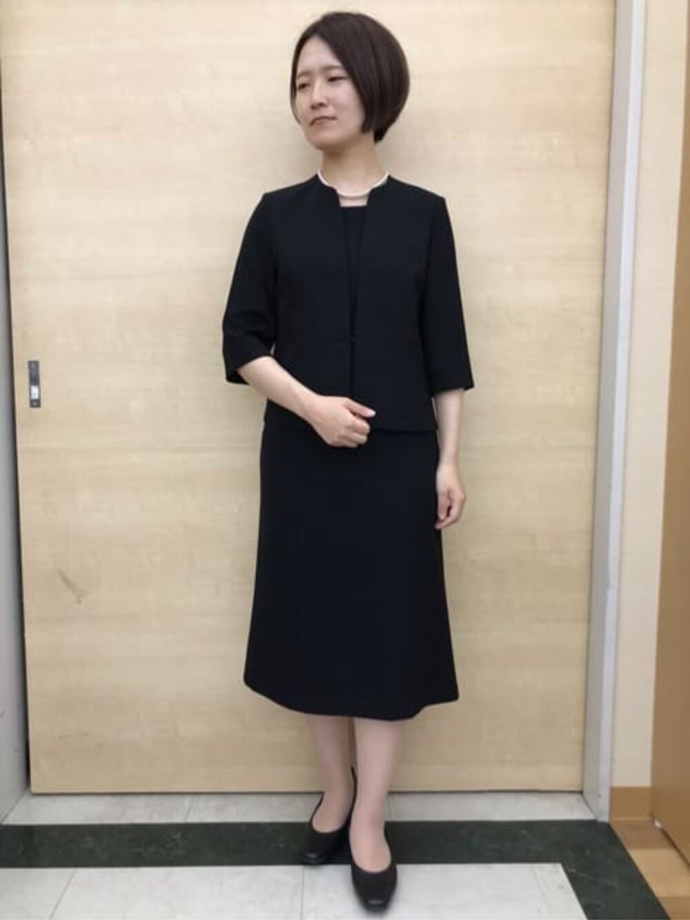 ブラック系のスーツセットを着用したレディースの冬コーディネートの5枚目の写真