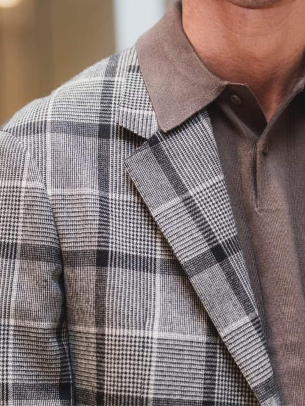 グレー系のテーラードジャケット、グレー系のスラックス、ブラウン系のニット/セーターを着用したメンズの冬コーディネートの6枚目の写真