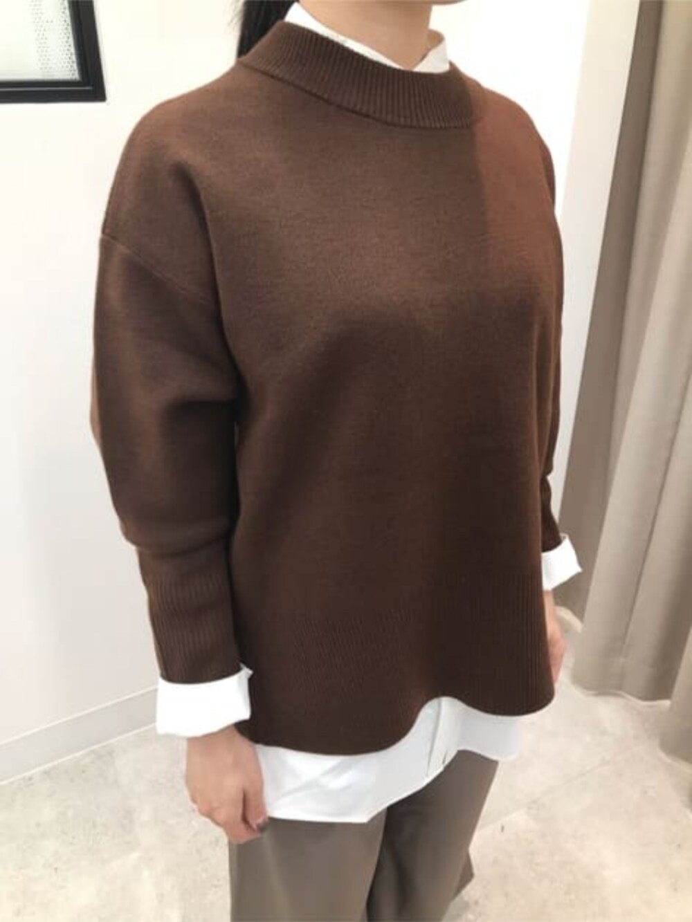 ブラウン系のニット/セーター、グリーン系のスラックス、ホワイト系のシャツ/ブラウスを着用したレディースの冬コーディネートの5枚目の写真