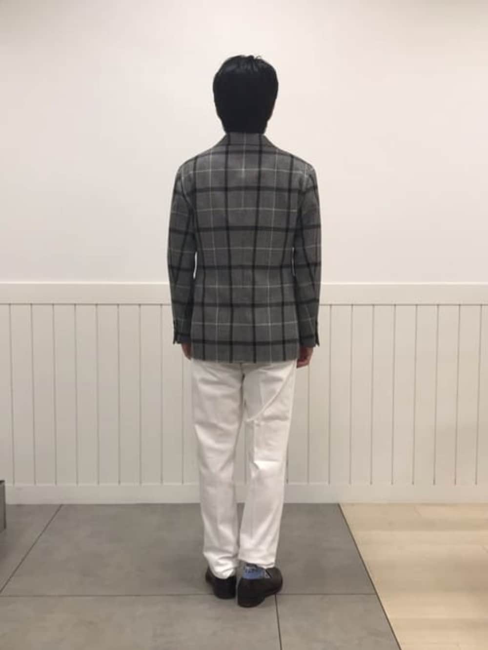 ホワイト系のスラックス、グレー系のテーラードジャケットを着用したメンズの冬コーディネートの4枚目の写真