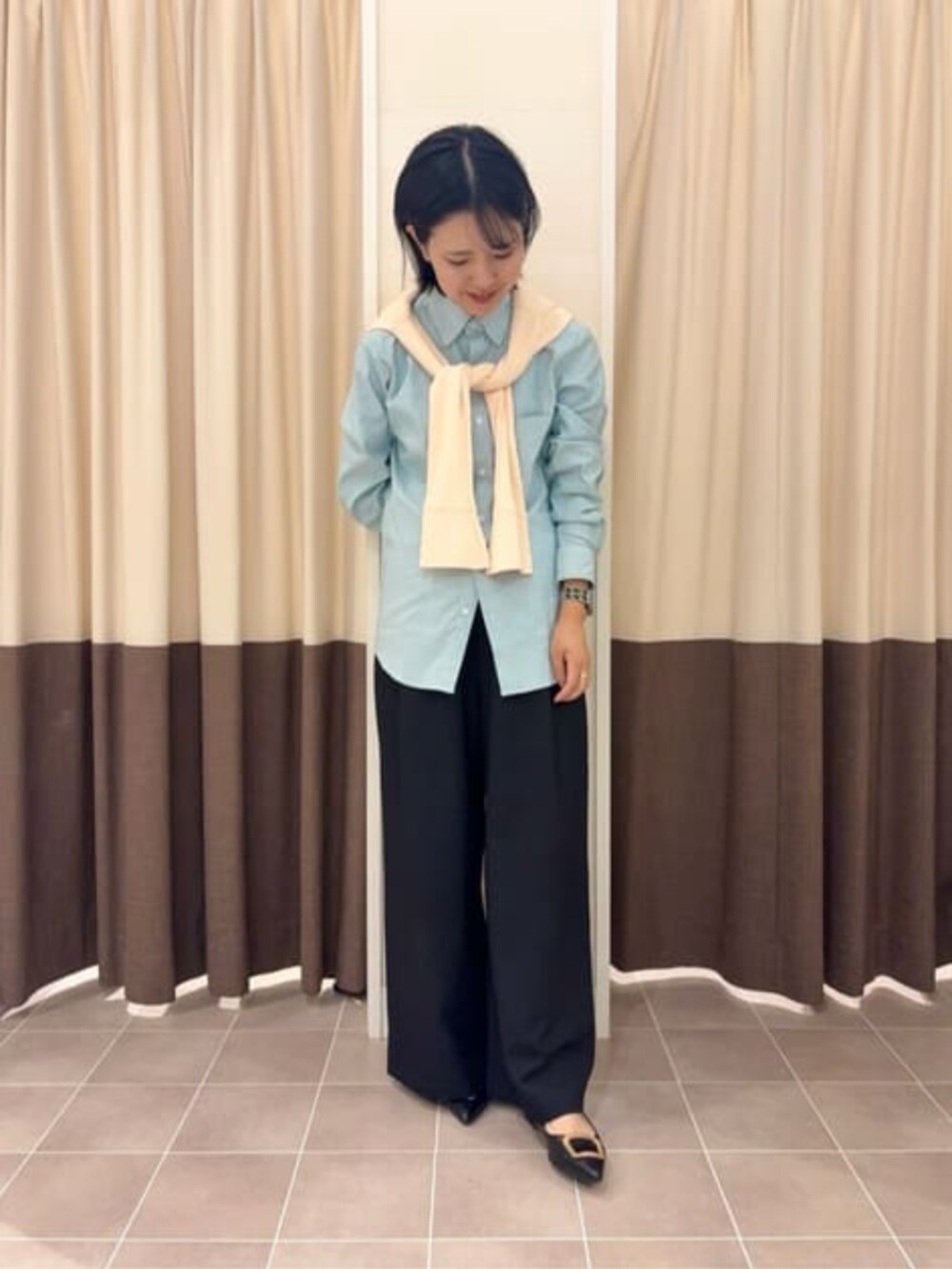 グレー系のテーラードジャケット、ブラック系のスラックス、グリーン系のシャツ/ブラウスを着用したレディースの冬コーディネートの5枚目の写真