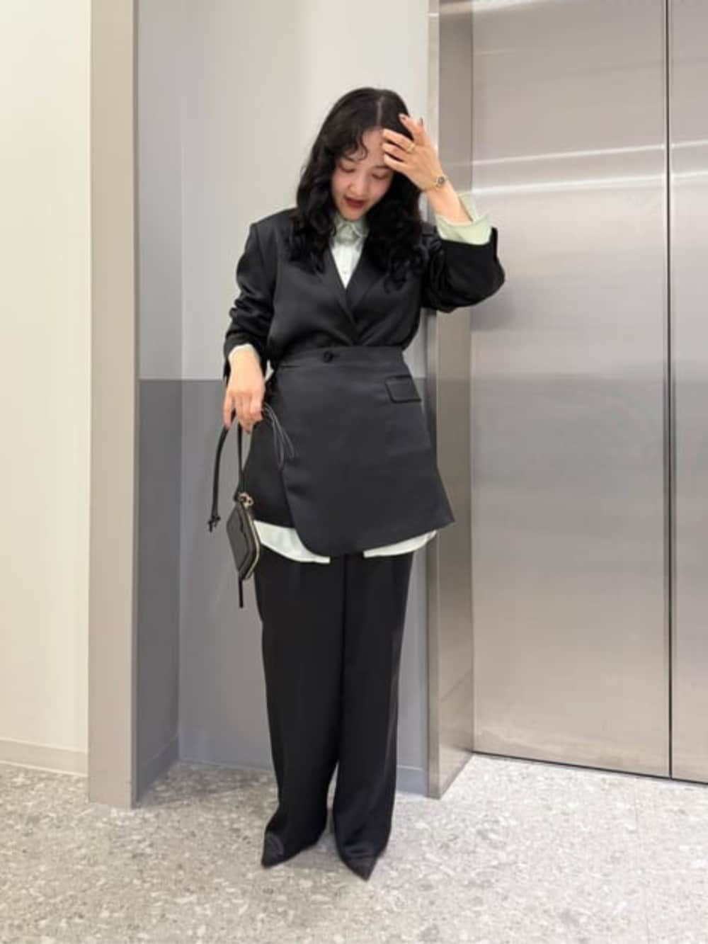 ブラック系のテーラードジャケット、ブラック系のその他パンツ、グリーン系のシャツ/ブラウスを着用したレディースの冬コーディネートの2枚目の写真