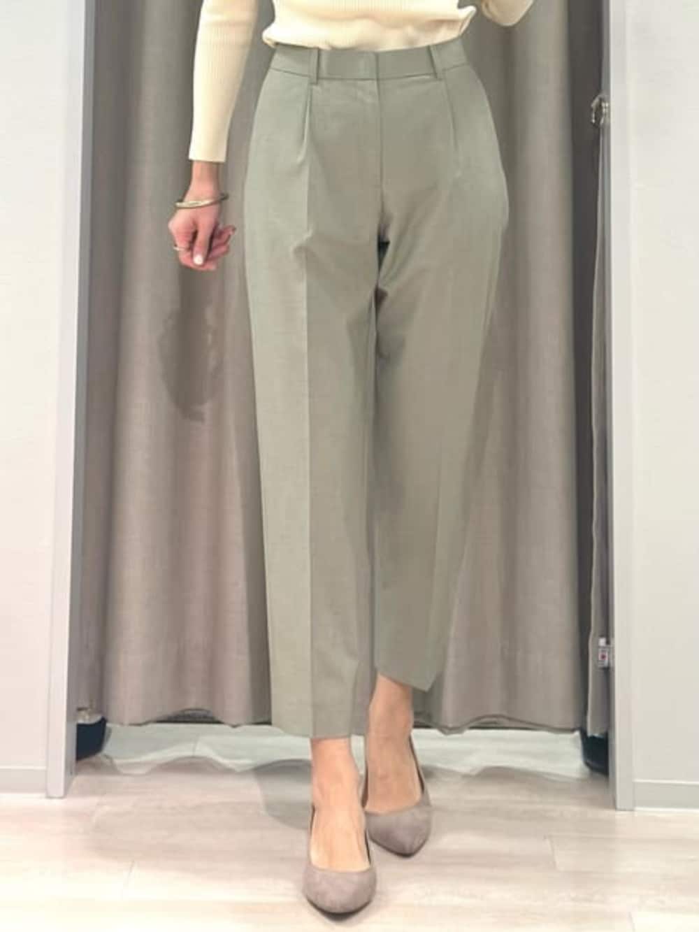 ベージュ系のニット/セーター、グリーン系のテーラードジャケット、グリーン系のスラックスを着用したレディースの冬コーディネートの10枚目の写真