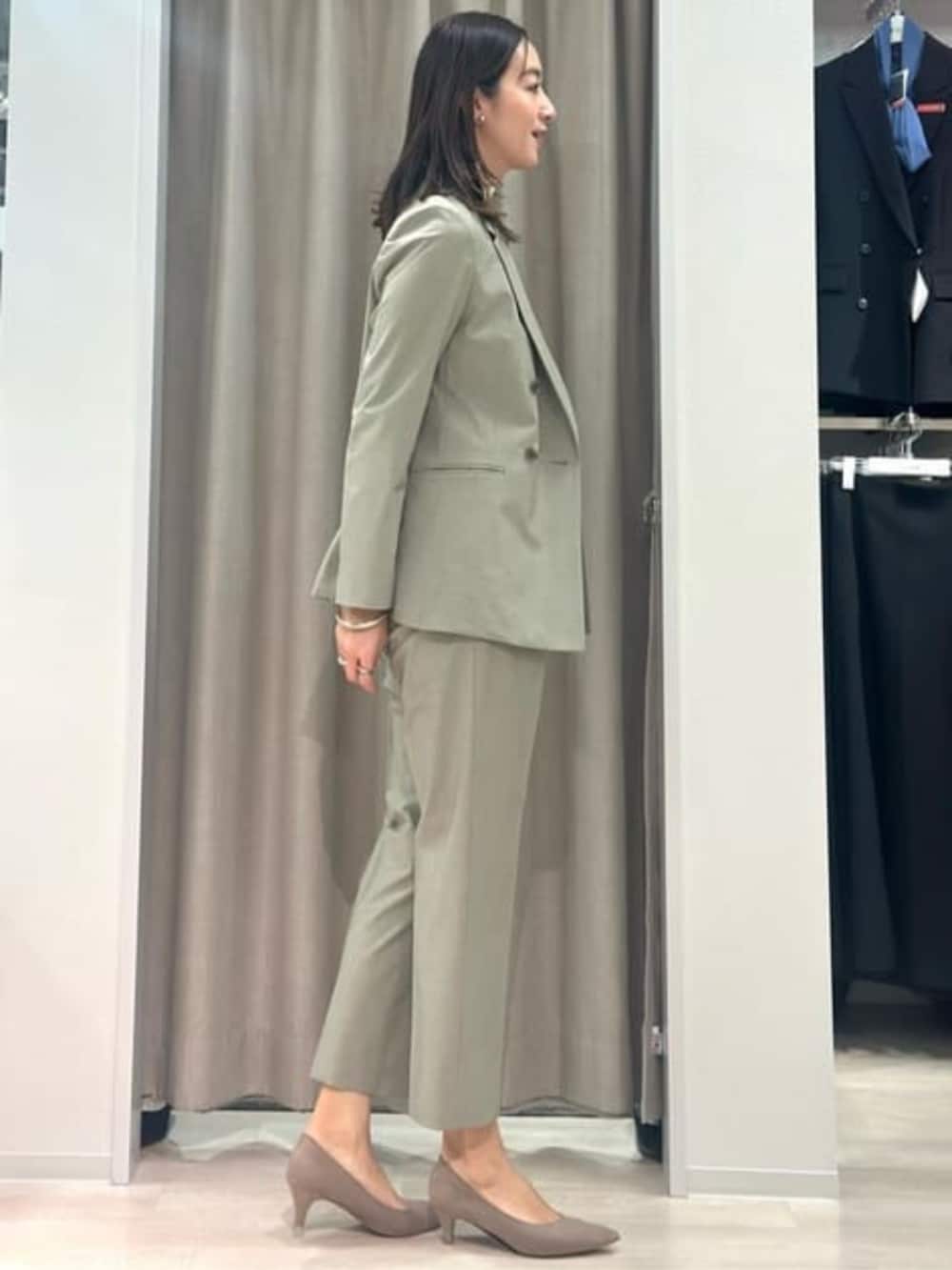 ベージュ系のニット/セーター、グリーン系のテーラードジャケット、グリーン系のスラックスを着用したレディースの冬コーディネートの7枚目の写真