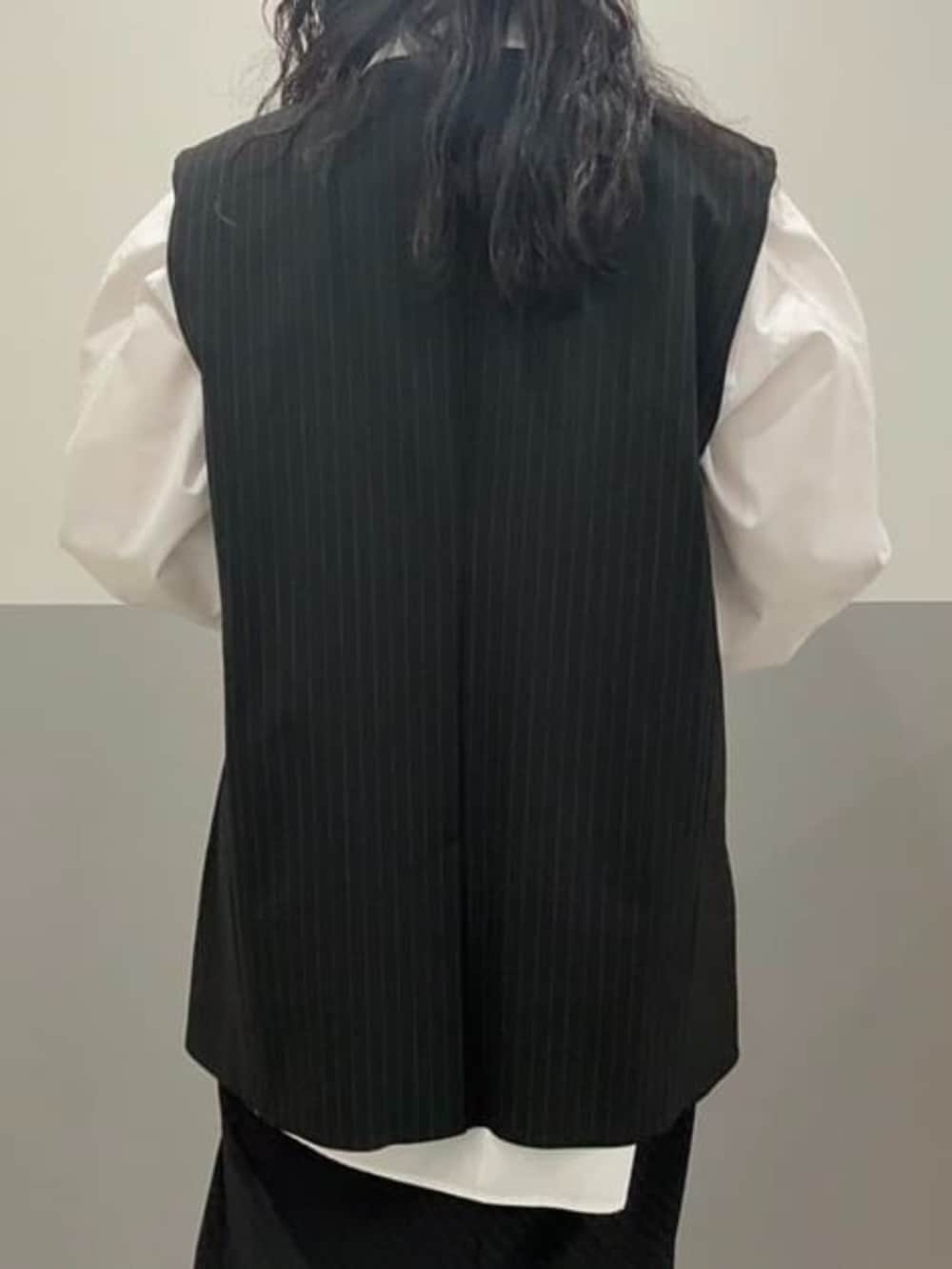 ホワイト系のシャツ/ブラウス、ブラック系のスカート、ブラック系のベストを着用したレディースの冬コーディネートの2枚目の写真