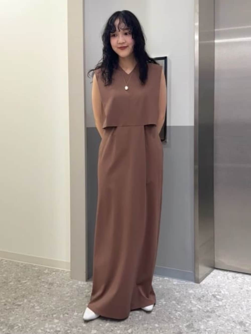 グレー系のベスト、ブラウン系のワンピースを着用したレディースの冬コーディネートの5枚目の写真