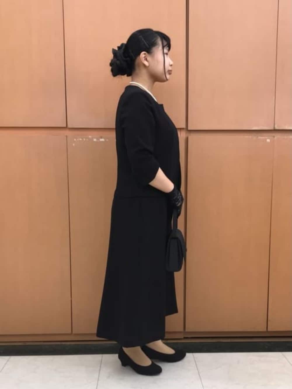 ブラック系のスーツセットを着用したレディースの冬コーディネートの5枚目の写真