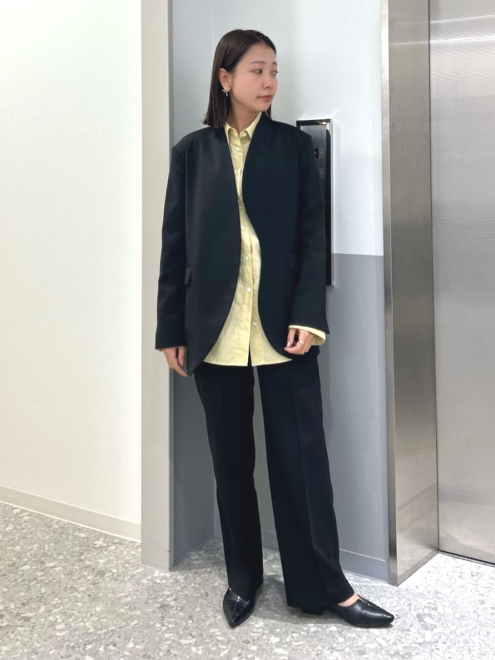 イエロー系のシャツ/ブラウス、ブラック系のその他パンツ、ブラック系のノーカラージャケットを着用したレディースの冬コーディネートの2枚目の写真