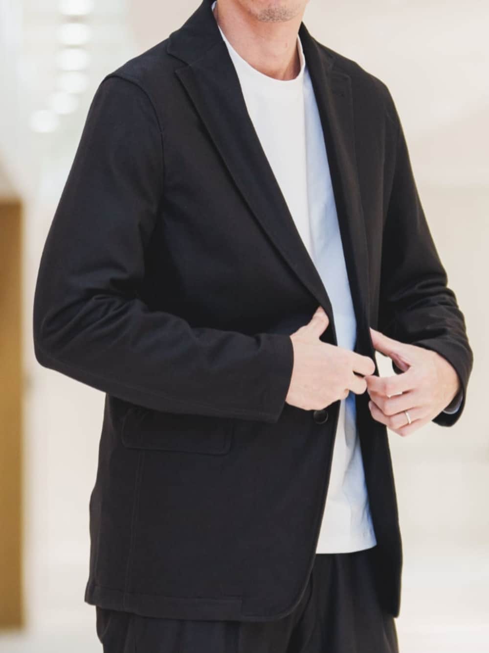 ブラック系のセットアップ、ホワイト系のTシャツ/カットソー、グレー系のバックパック/リュックを着用したメンズの冬コーディネートの3枚目の写真