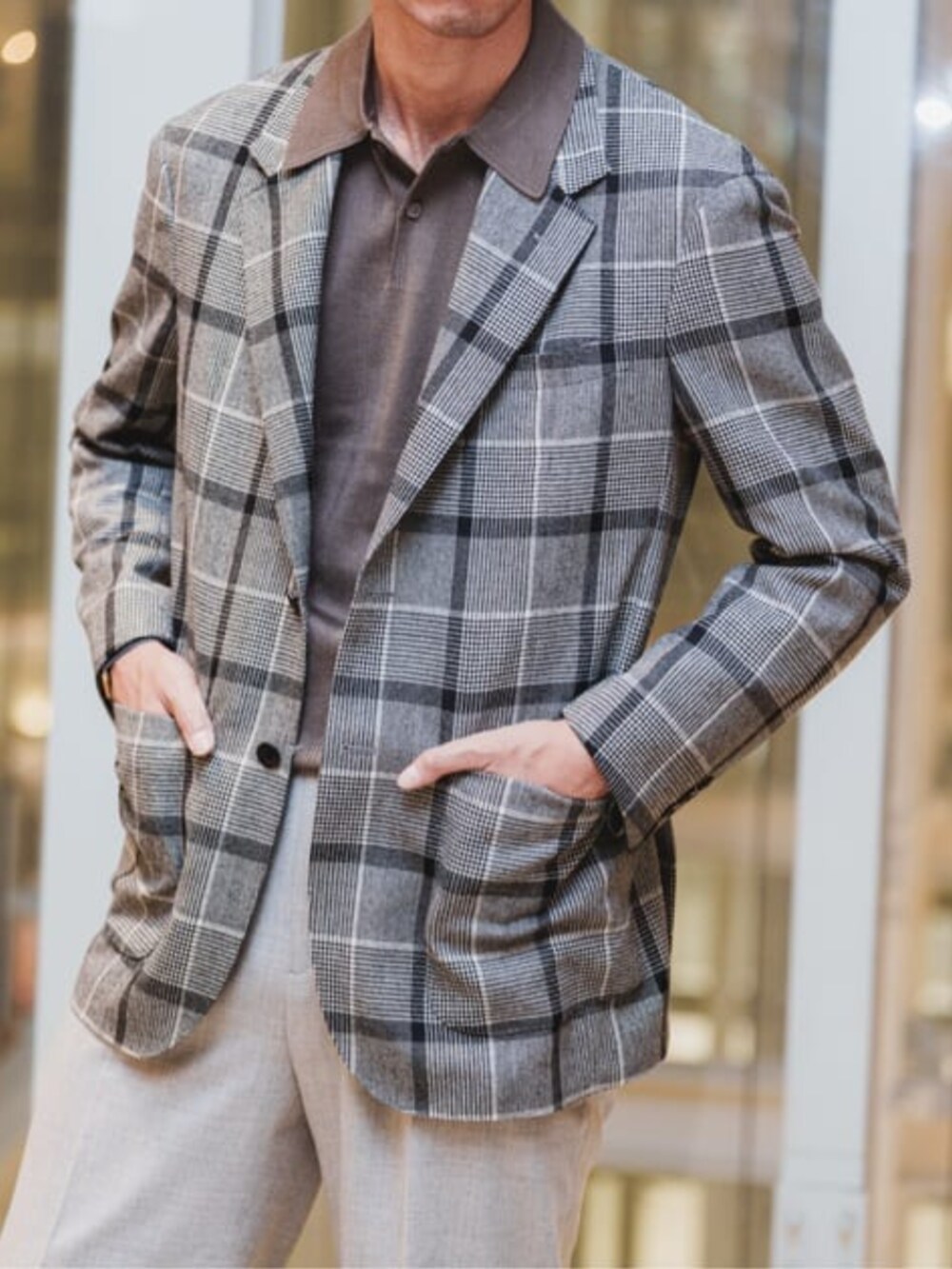 グレー系のテーラードジャケット、グレー系のスラックス、ブラウン系のニット/セーターを着用したメンズの冬コーディネートの3枚目の写真