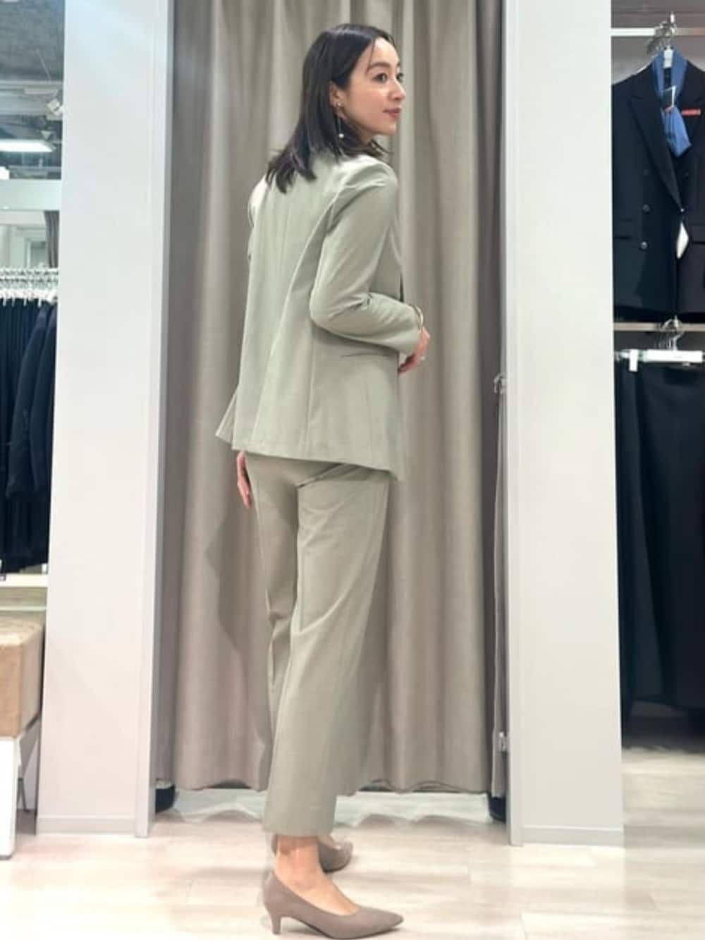 ベージュ系のニット/セーター、グリーン系のテーラードジャケット、グリーン系のスラックスを着用したレディースの冬コーディネートの6枚目の写真