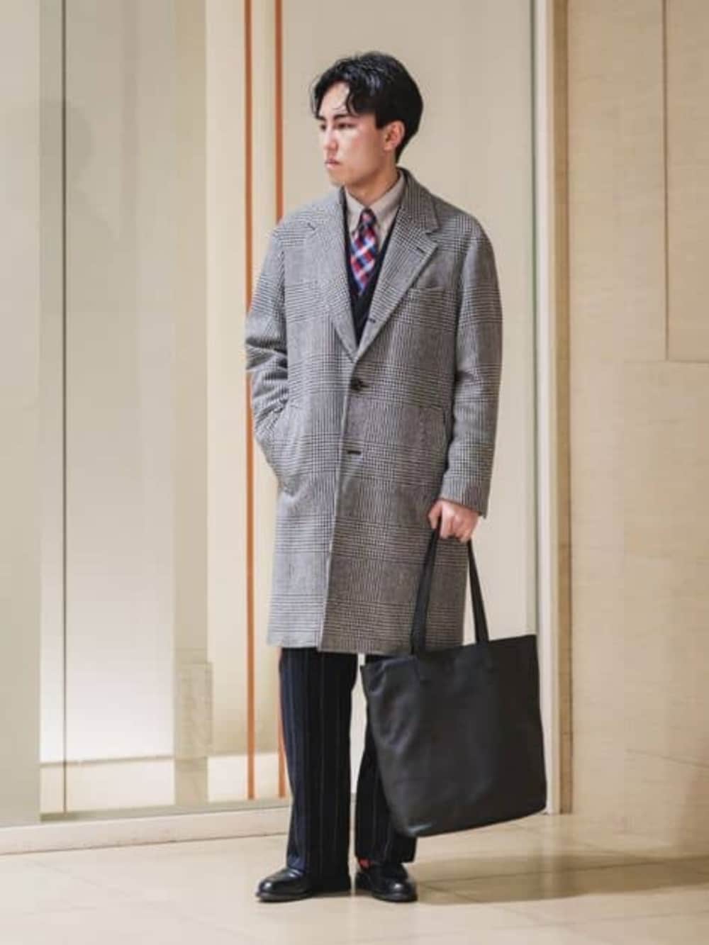 グレー系のチェスターコートを着用したメンズの冬コーディネートの2枚目の写真