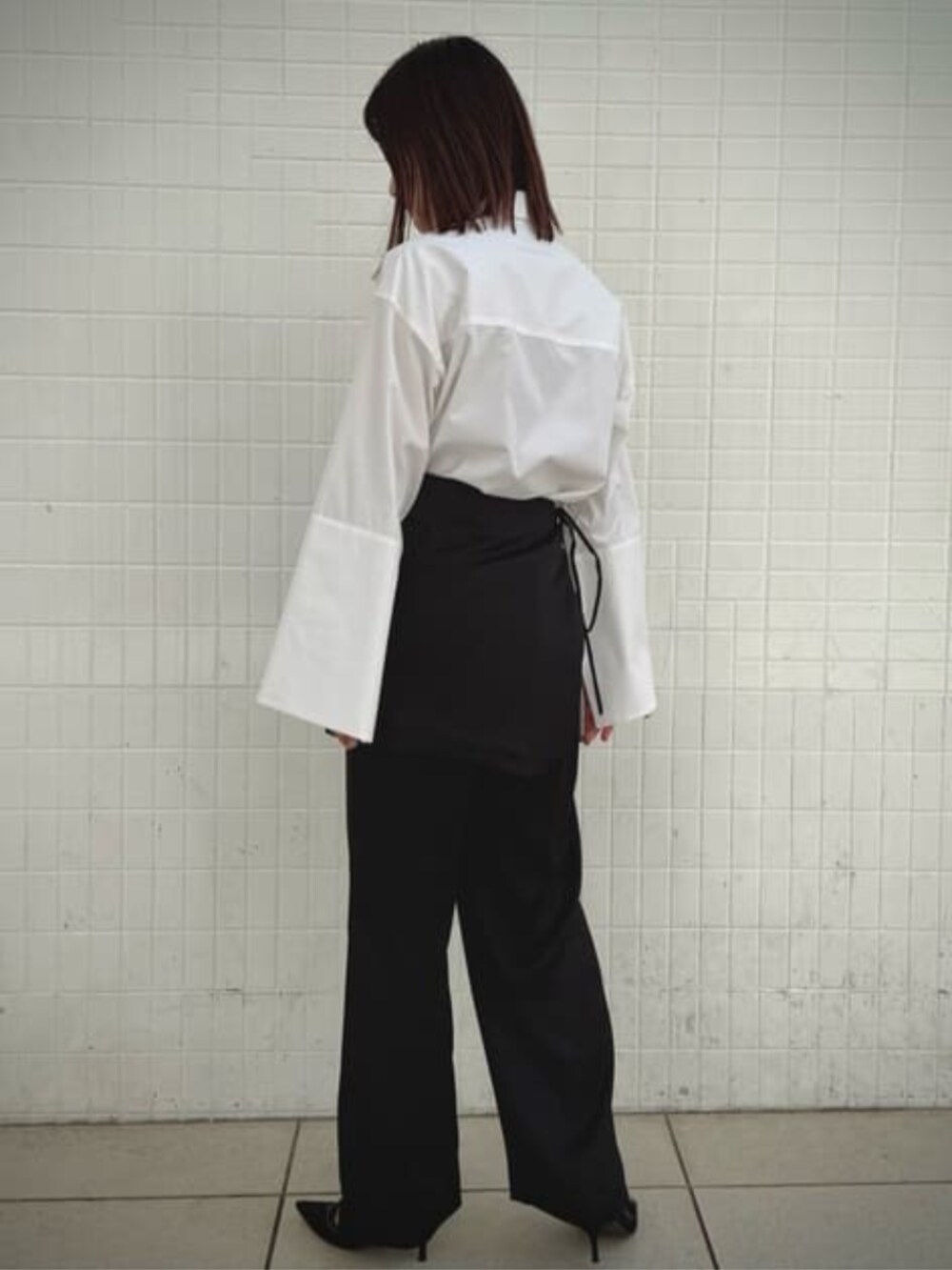 ブラック系のその他パンツ、ブラック系のテーラードジャケット、ホワイト系のシャツ/ブラウスを着用したレディースの冬コーディネートの2枚目の写真