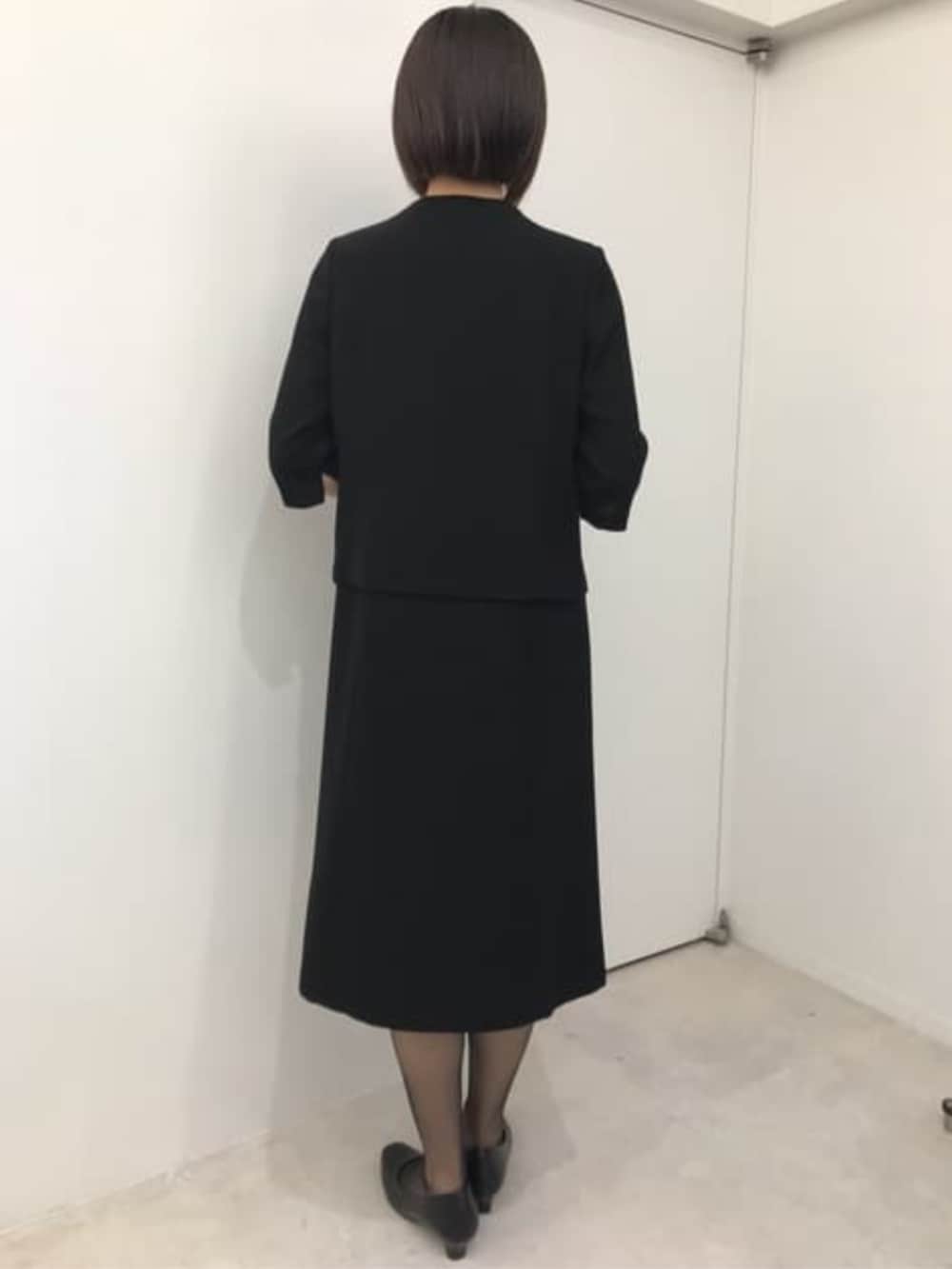 ブラック系のスーツセットを着用したレディースの冬コーディネートの4枚目の写真