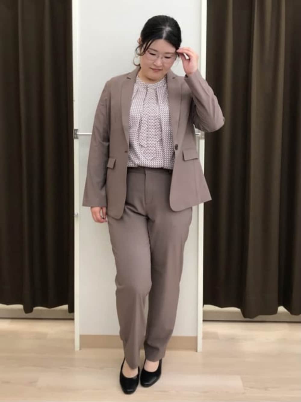 ブラウン系のスーツパンツ、ブラウン系のスーツジャケット、レッド系のシャツ/ブラウスを着用したレディースの夏コーディネートの2枚目の写真