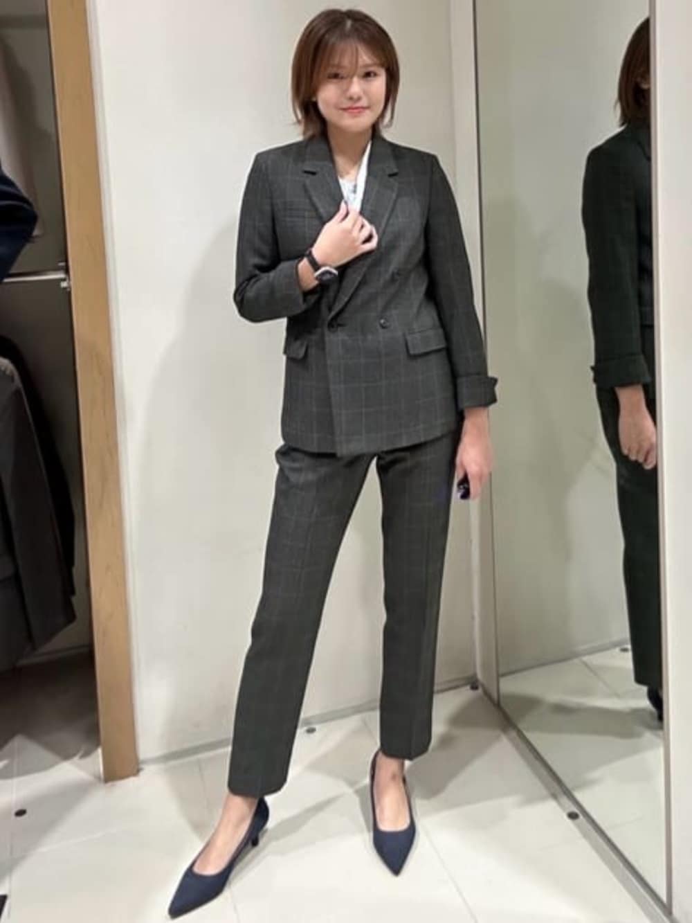 グレー系のテーラードジャケット、グレー系のスラックス、ブルー系のシャツ/ブラウスを着用したレディースの冬コーディネートの2枚目の写真