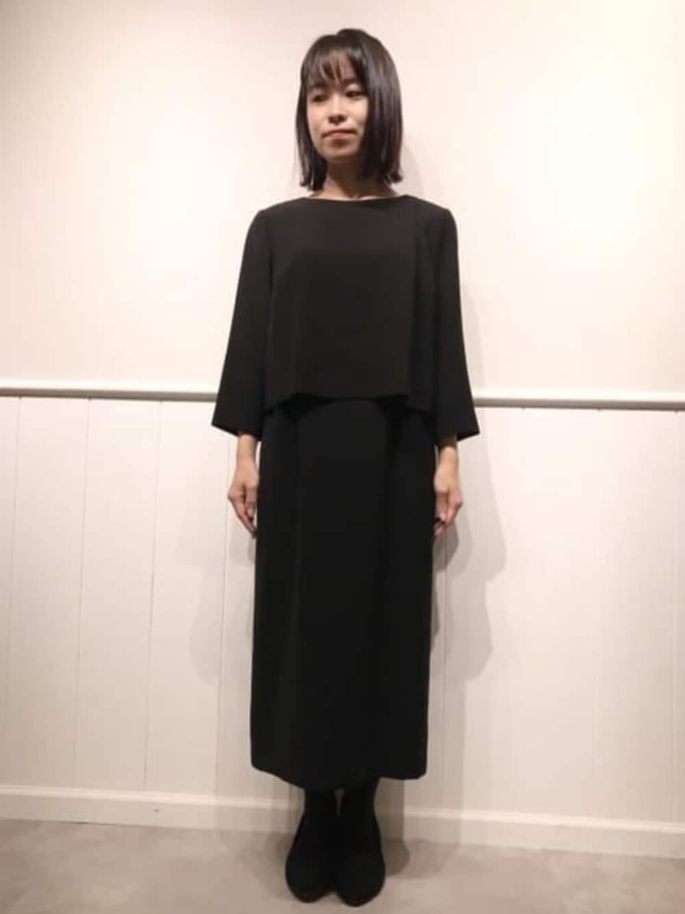 ブラック系のスーツセットを着用したレディースの冬コーディネートの2枚目の写真