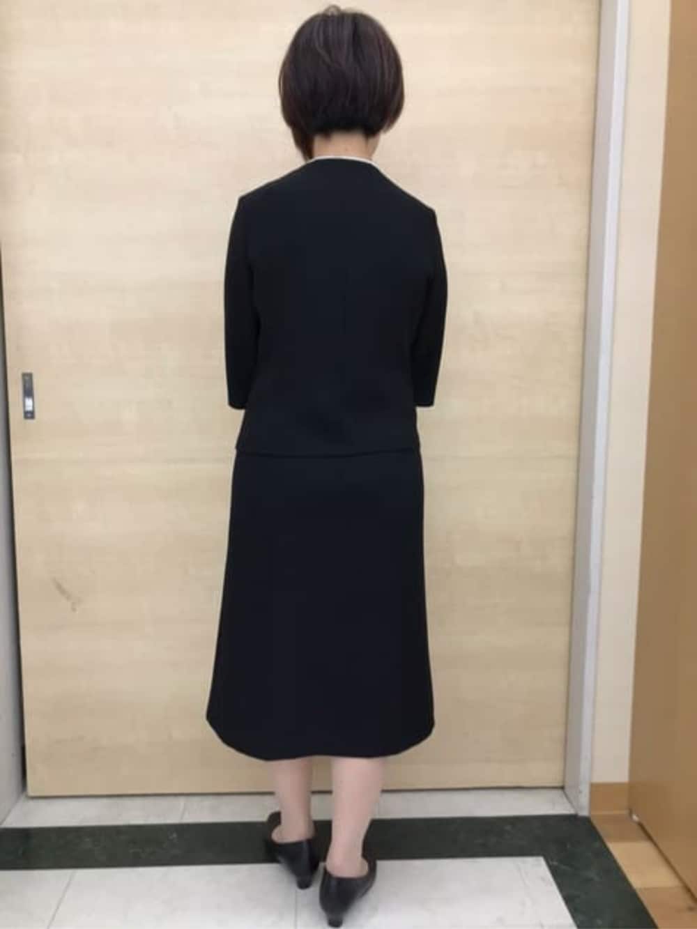 ブラック系のスーツセットを着用したレディースの冬コーディネートの4枚目の写真