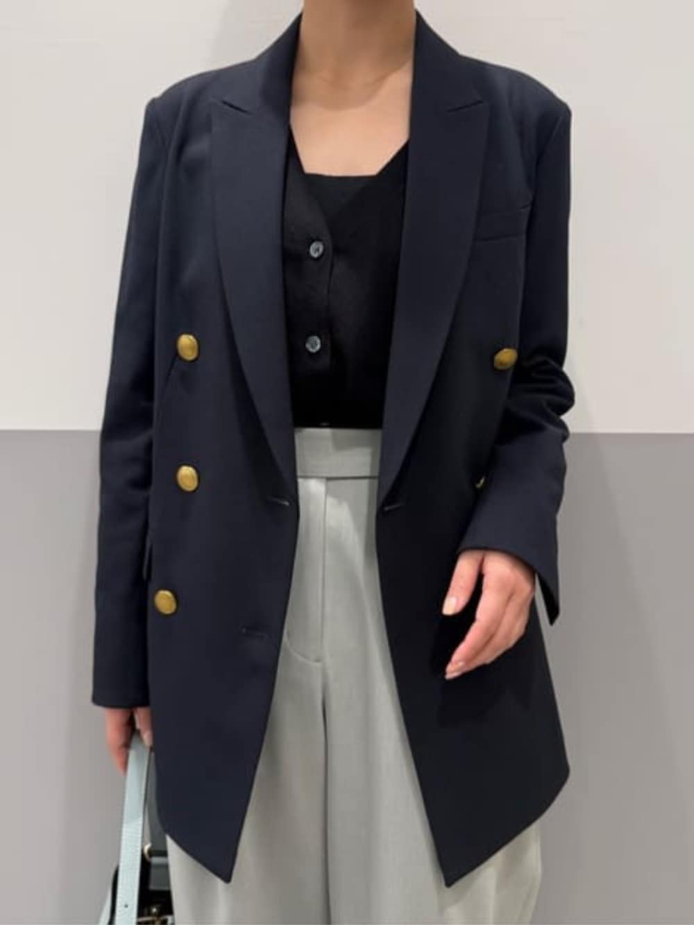 ブルー系のテーラードジャケット、グリーン系のその他パンツ、グリーン系のハンドバッグを着用したレディースの春コーディネートの2枚目の写真