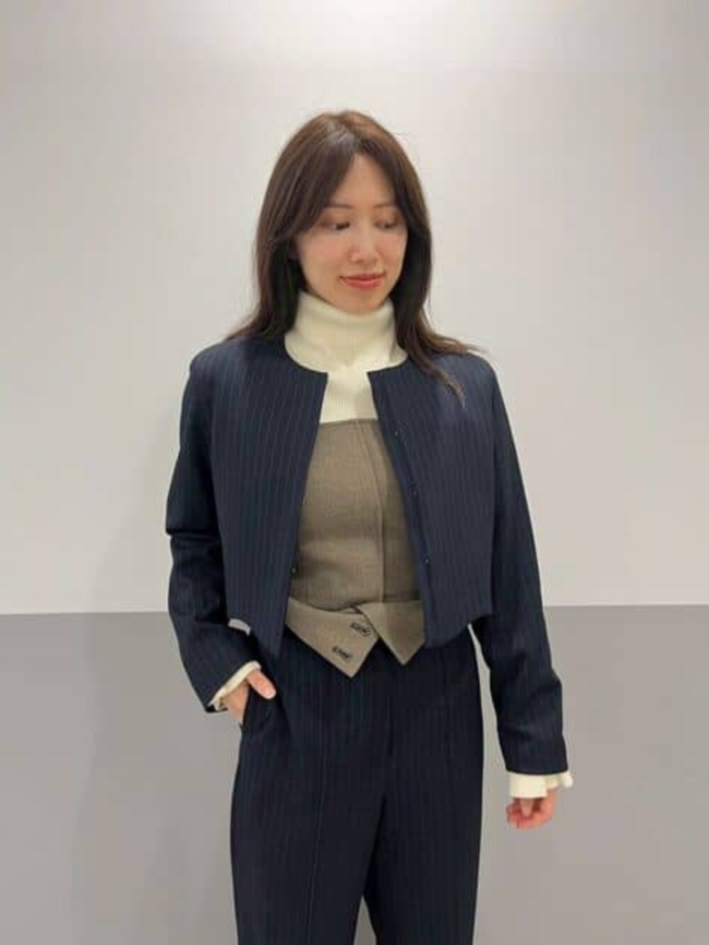 ベージュ系のその他パンツ、ホワイト系のニット/セーター、ブルー系のブルゾンを着用したレディースの冬コーディネートの4枚目の写真