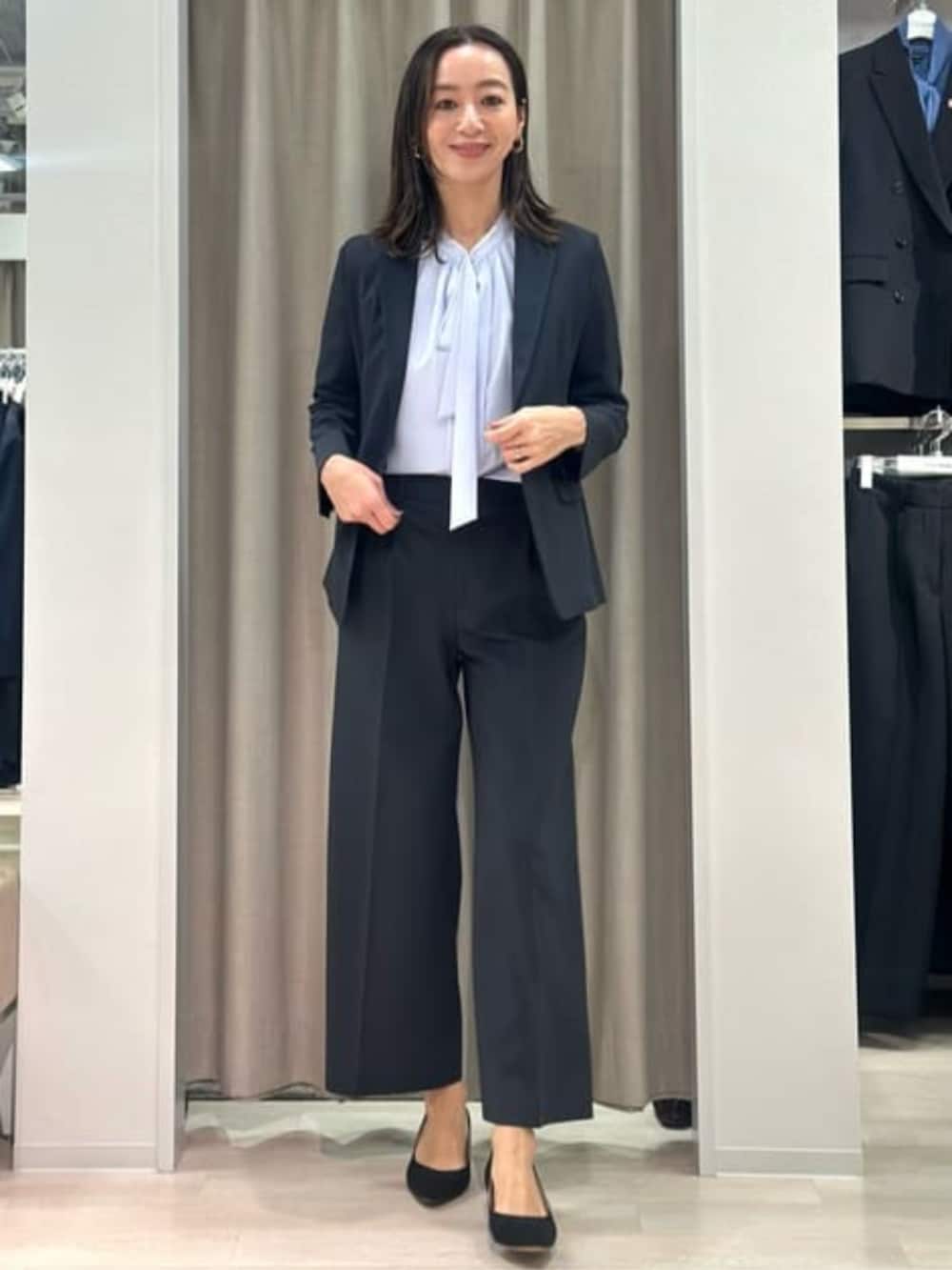 パープル系のシャツ/ブラウス、ブラック系のテーラードジャケット、ブラック系のスラックスを着用したレディースの冬コーディネートの2枚目の写真