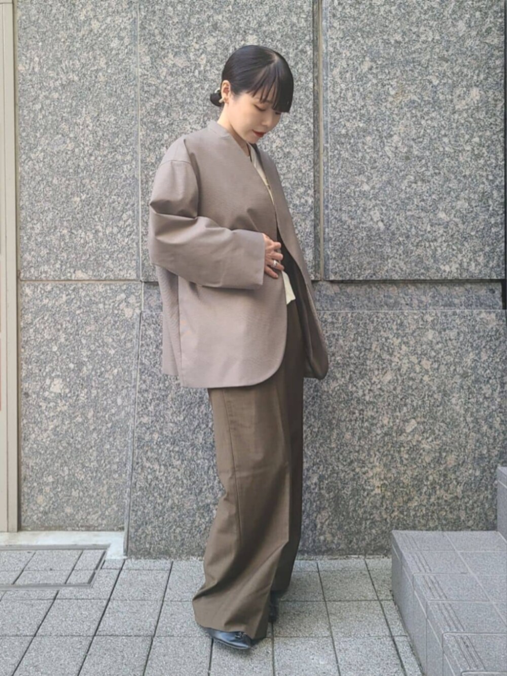 ベージュ系のノーカラージャケット、ホワイト系のTシャツ/カットソーを着用したレディースの冬コーディネートの2枚目の写真