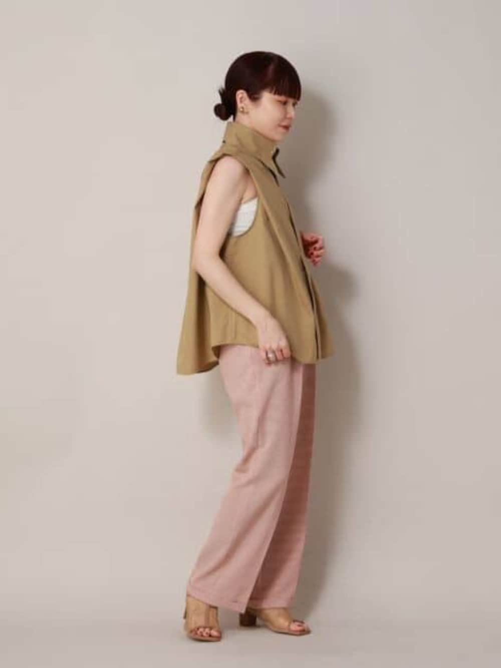 ベージュ系のシャツ/ブラウス、オレンジ系のスラックスを着用したレディースの冬コーディネートの2枚目の写真