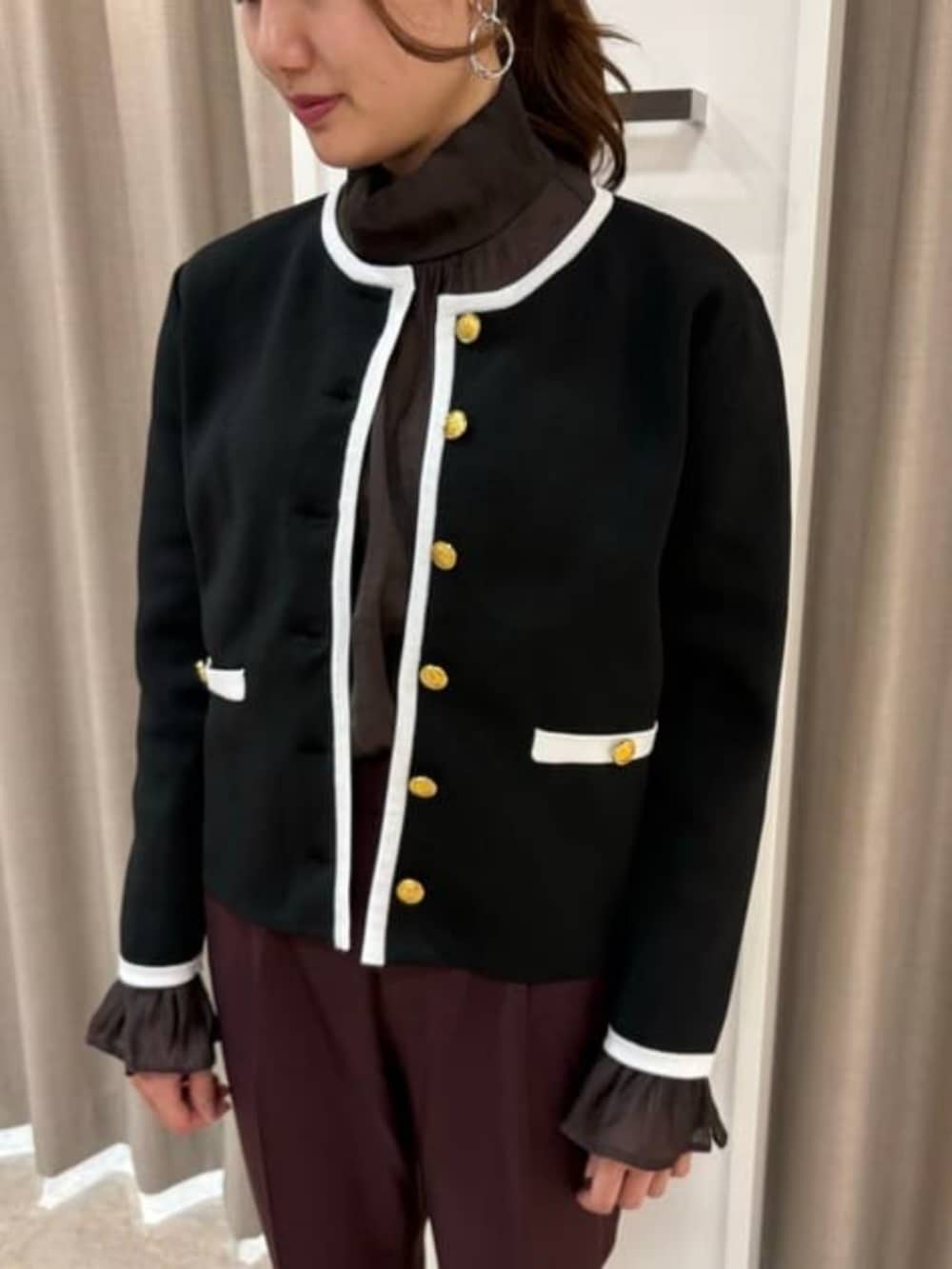 パープル系のスラックス、ブラウン系のシャツ/ブラウス、ブラック系のニット/セーターを着用したレディースの冬コーディネートの2枚目の写真