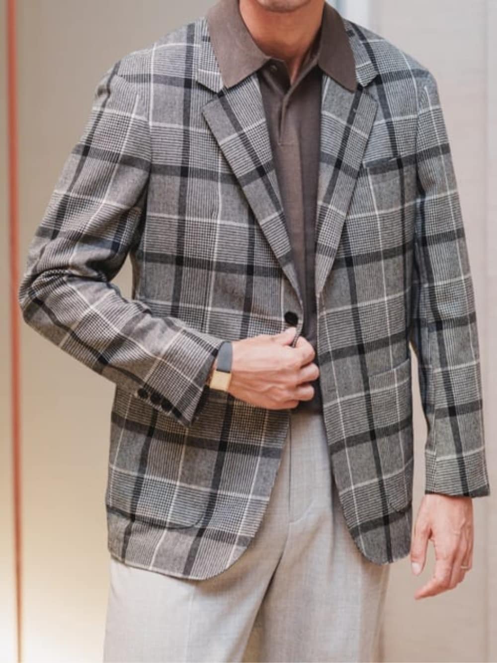 グレー系のテーラードジャケット、グレー系のスラックス、ブラウン系のニット/セーターを着用したメンズの冬コーディネートの2枚目の写真