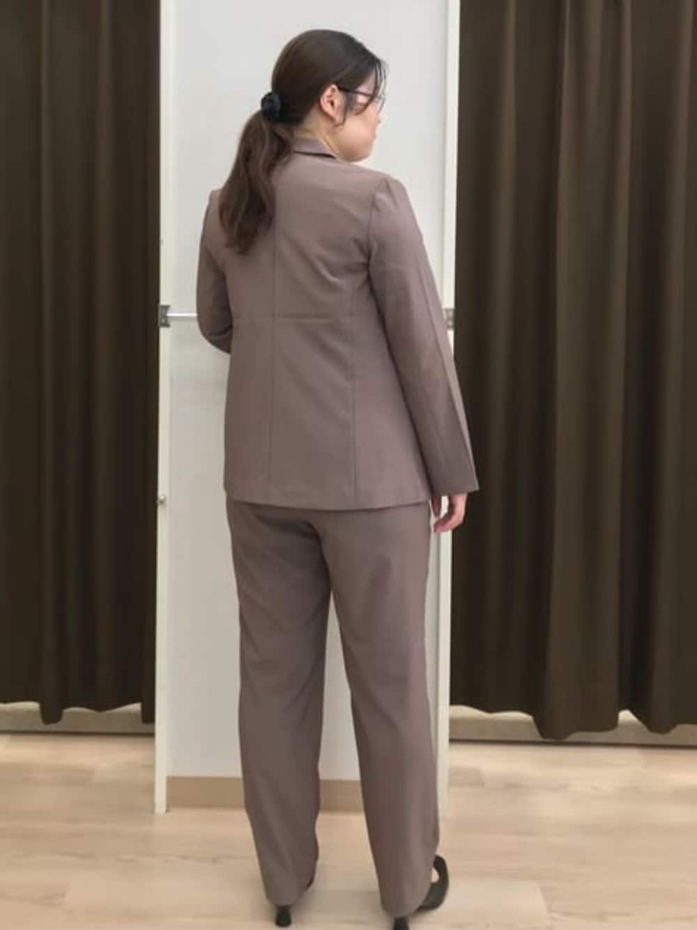 ブラウン系のスーツパンツ、ブラウン系のスーツジャケット、レッド系のシャツ/ブラウスを着用したレディースの夏コーディネートの4枚目の写真