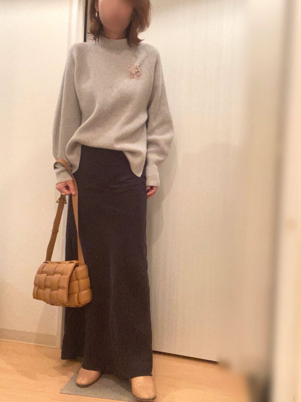 グレー系のニット/セーター、ブラック系のスカート、ブルー系のその他アウターを着用したレディースの冬コーディネートの2枚目の写真